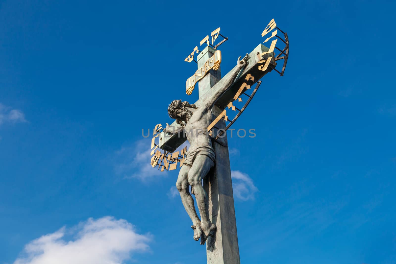 Close up detailed view of historical gothic granit sculptures on Charles Bridge in Prague, on bright blue sky background.