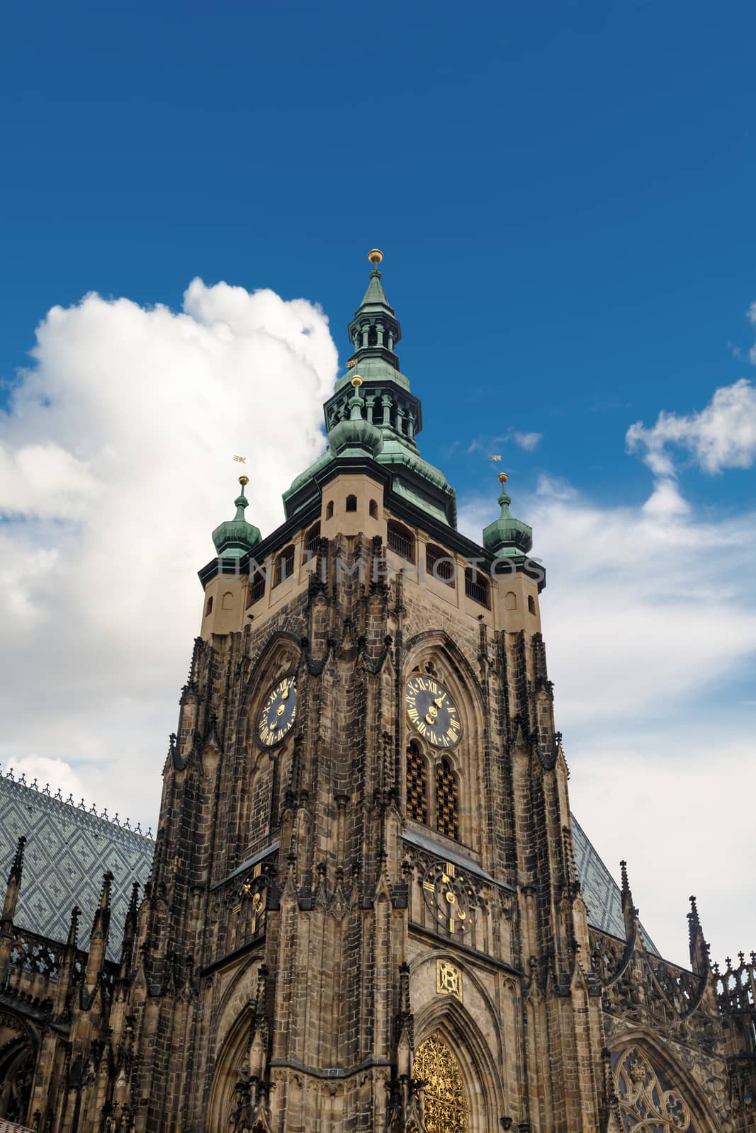 Bottom view of historical gothic St. Vitus Cathedral in old town of Prague, found in 1344, on cloudy blue sky background.