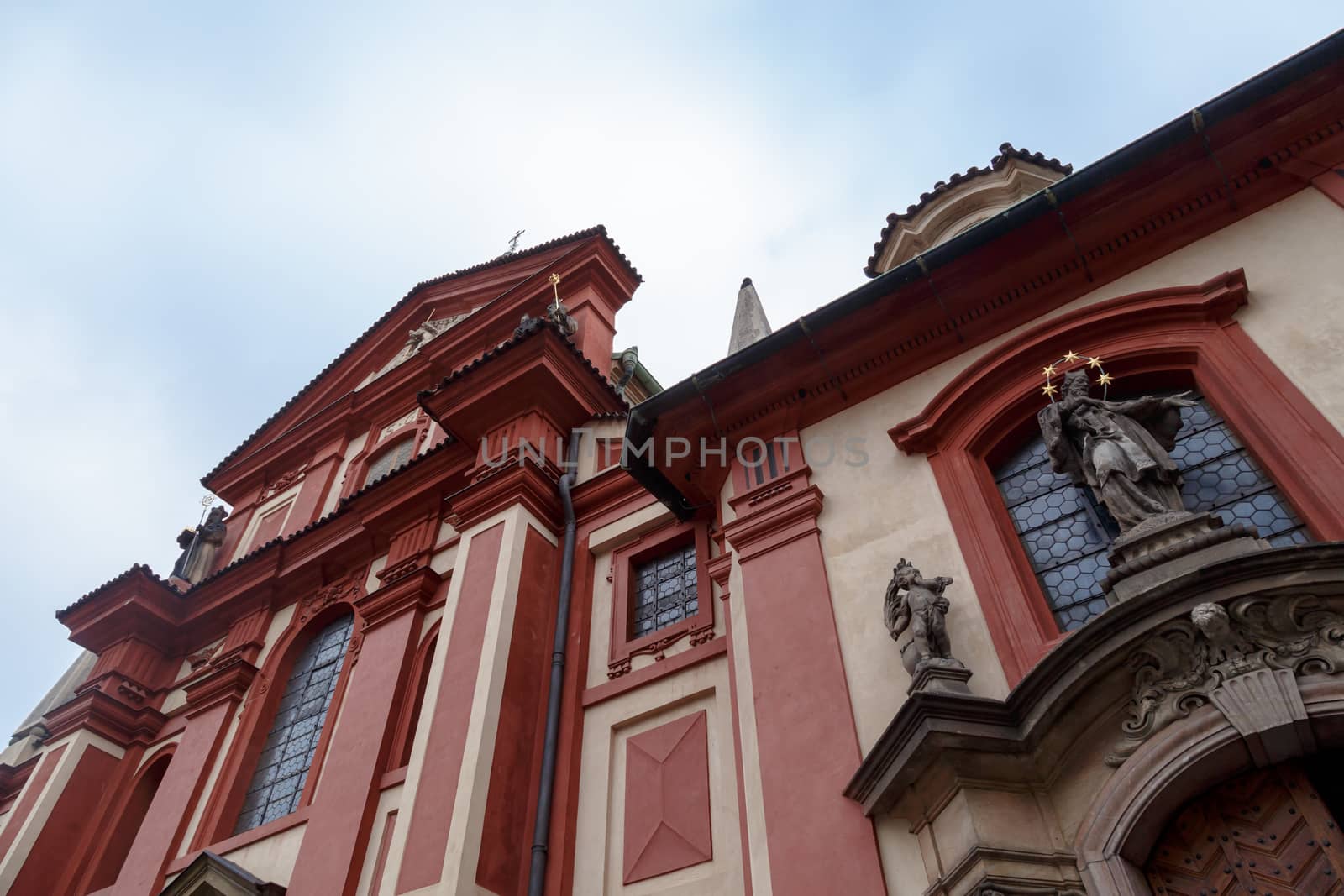 Bottom view of St George Basilica, the oldest living church built within Prag Castle, on cloudy sky background.