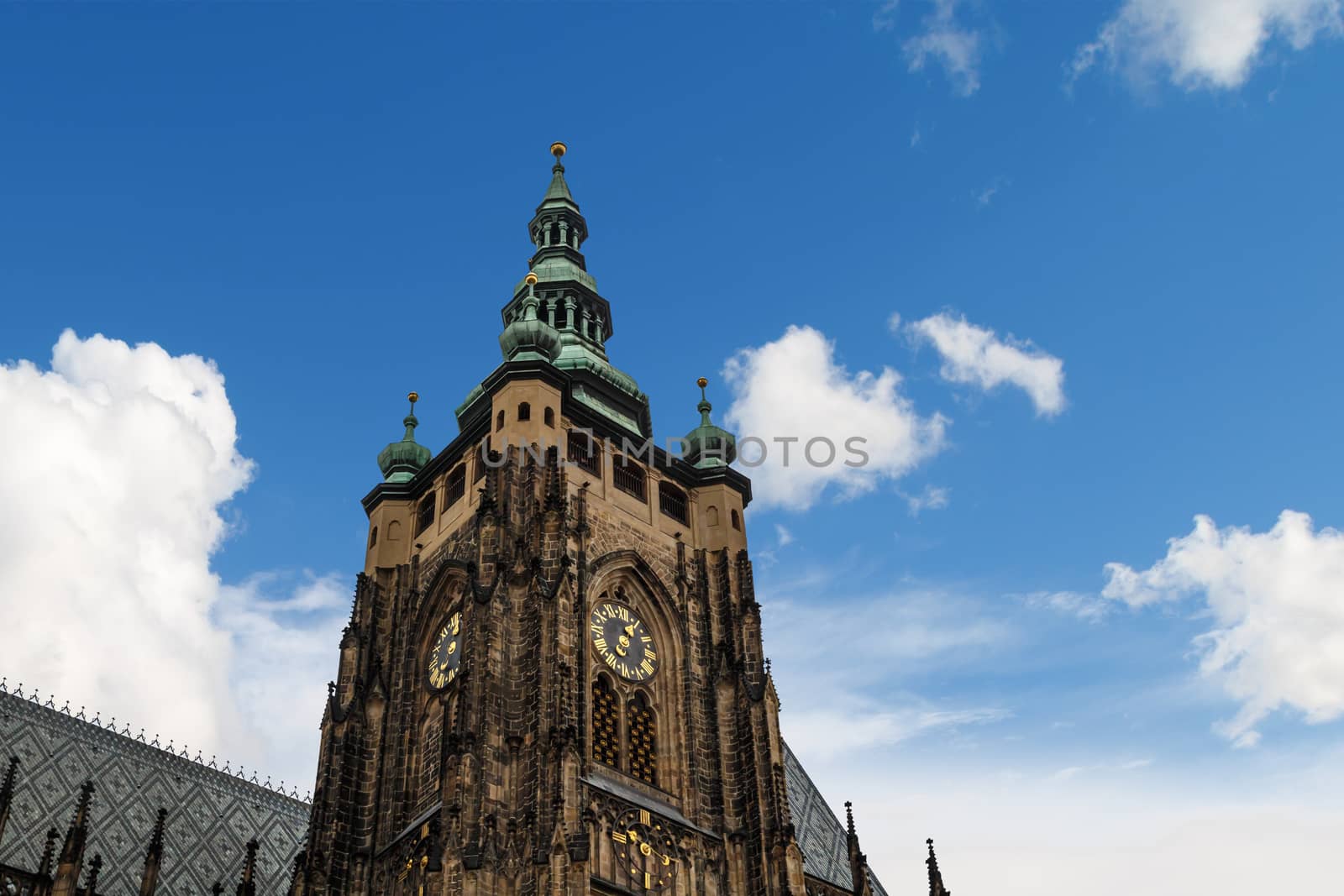 Bottom view of historical gothic St. Vitus Cathedral in old town of Prague, found in 1344, on cloudy blue sky background.