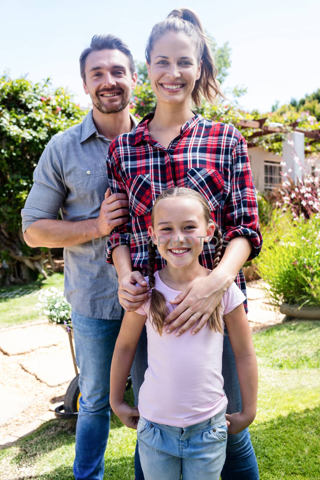 Happy family standing in the garden on a sunny day