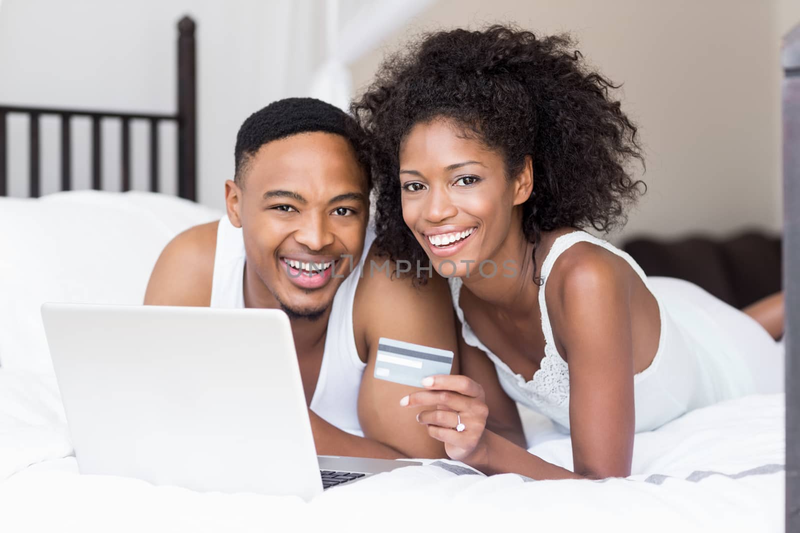 Happy couple shopping online through laptop using credit card  by Wavebreakmedia
