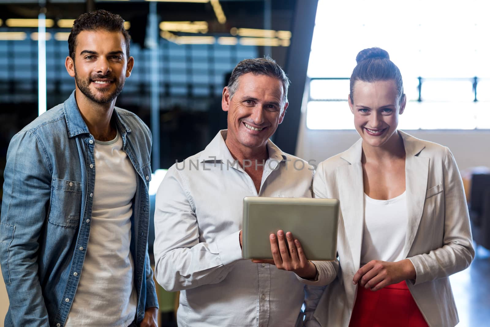 Portrait of businessmen and businesswoman holding digital tablet in the office