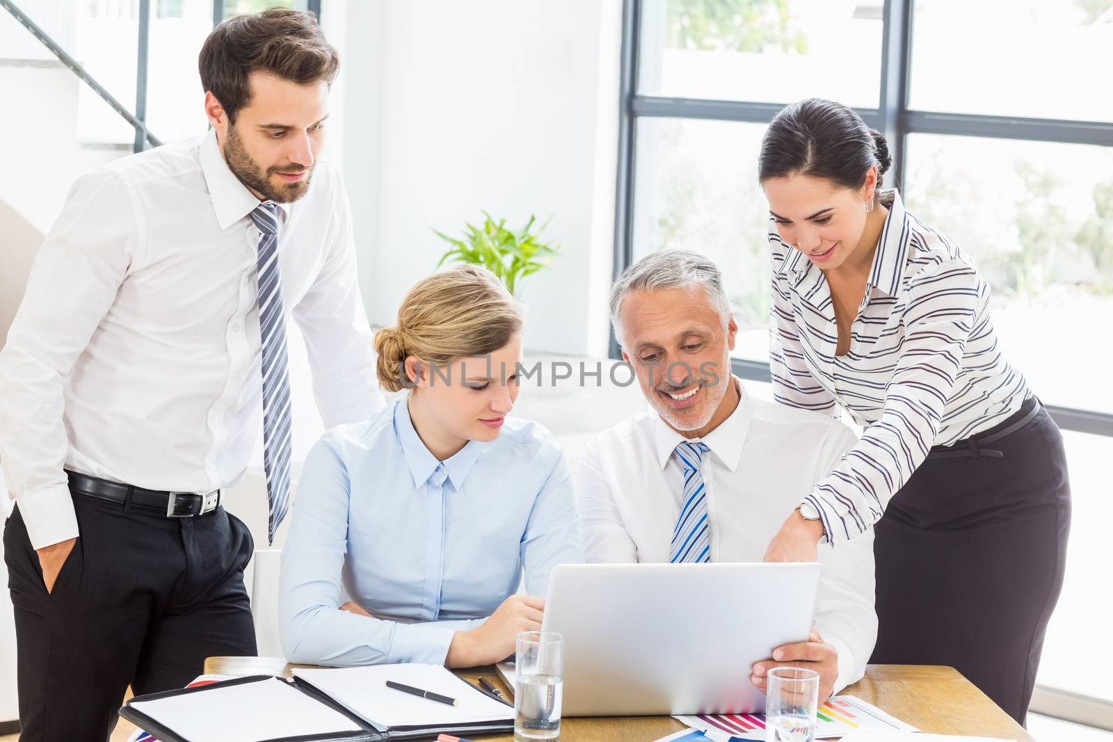 Business colleagues discussing office work on laptop by Wavebreakmedia
