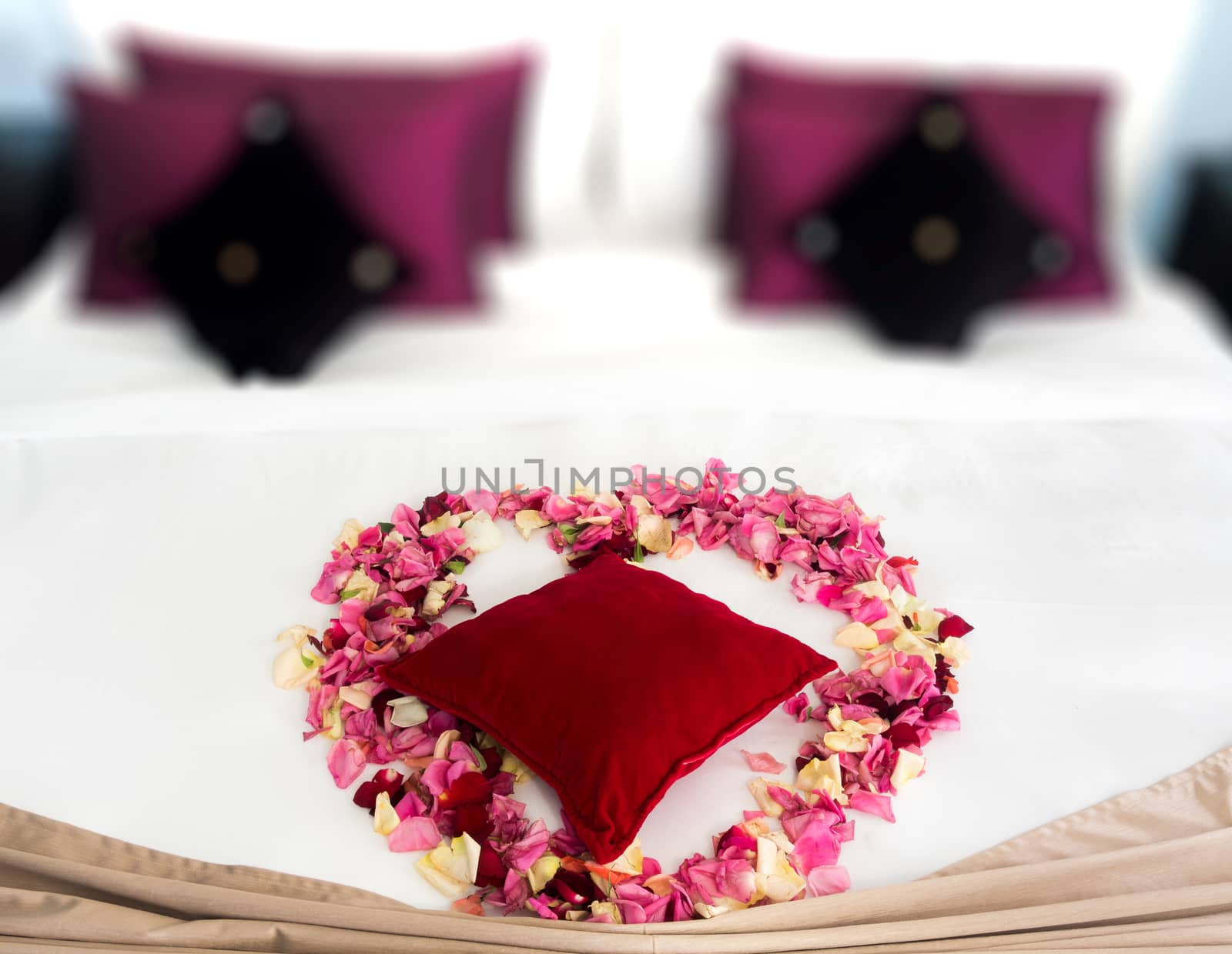 Heart of rose petals on a romantic bed