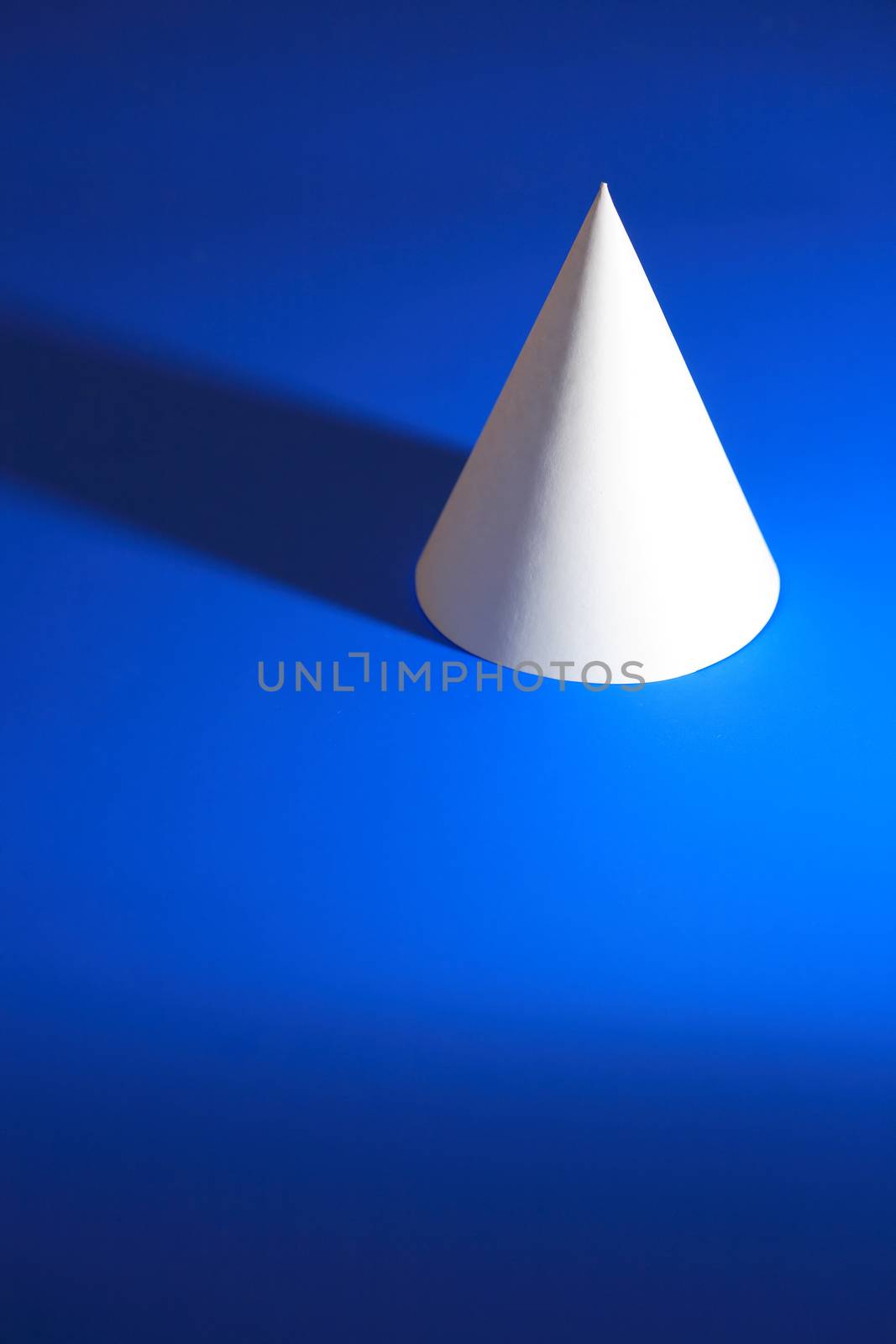 Geometry concept. One white paper cone on blue background