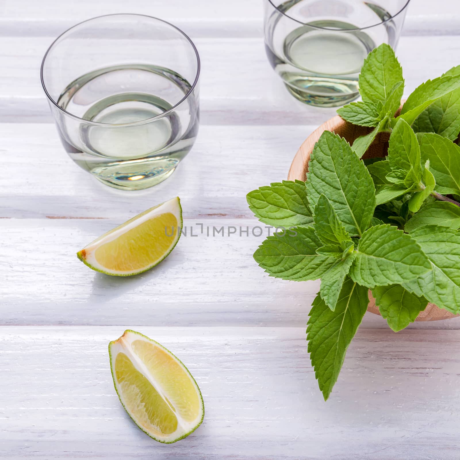 Ingredients for making mojitos mint leaves, lime,lemon and vodka by kerdkanno