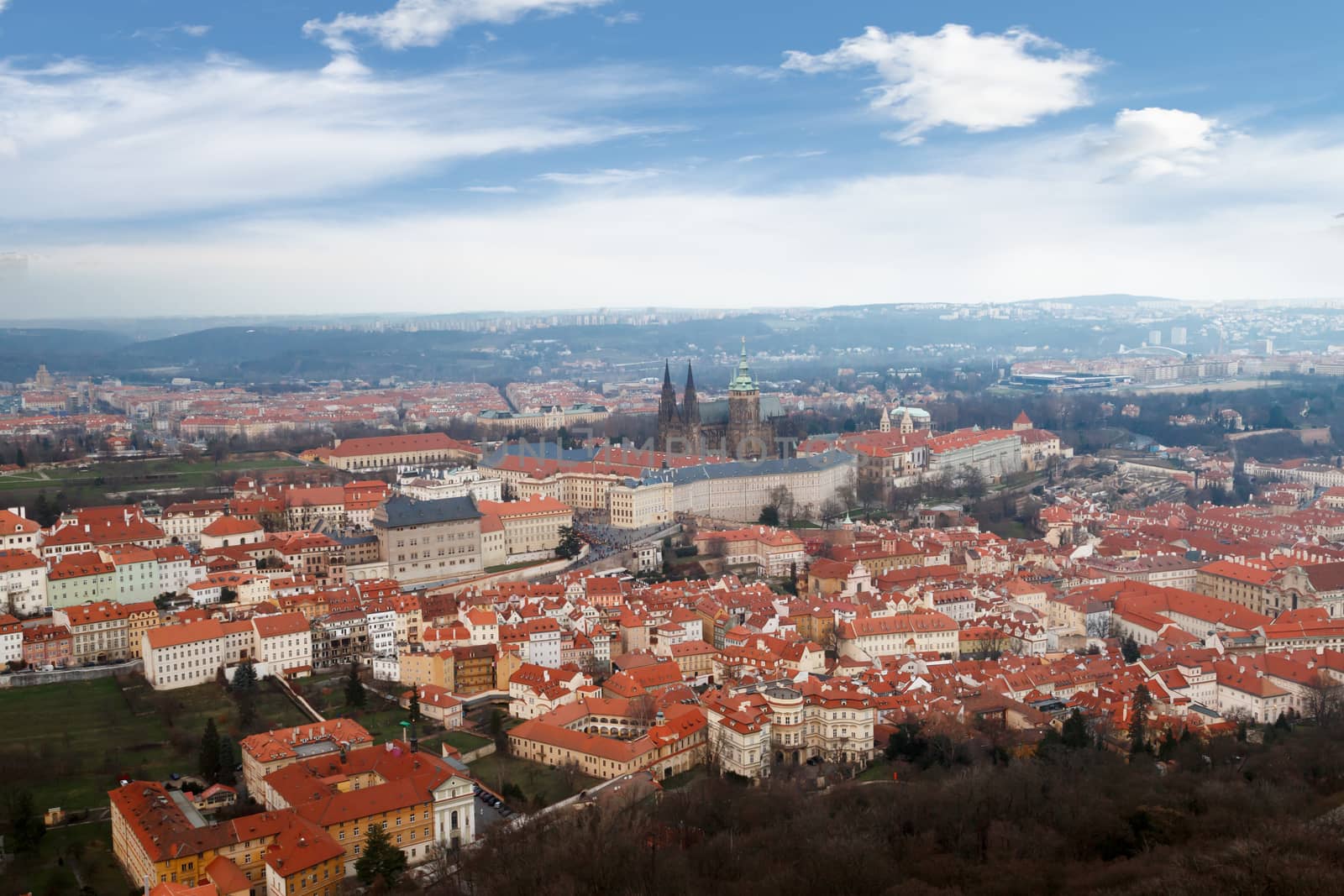 General top view of historical gothic Prague cityscape with old buildings and towers around, on cloudy sky background.