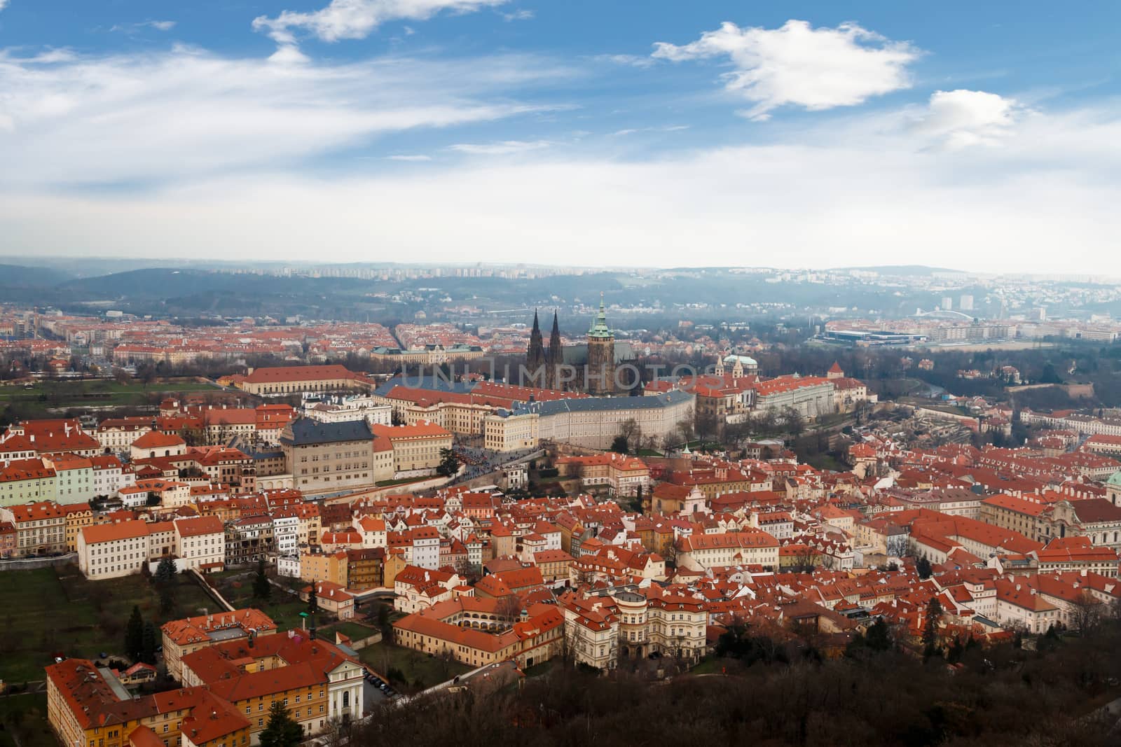 General top view of historical gothic Prague cityscape with old buildings and towers around, on cloudy sky background.