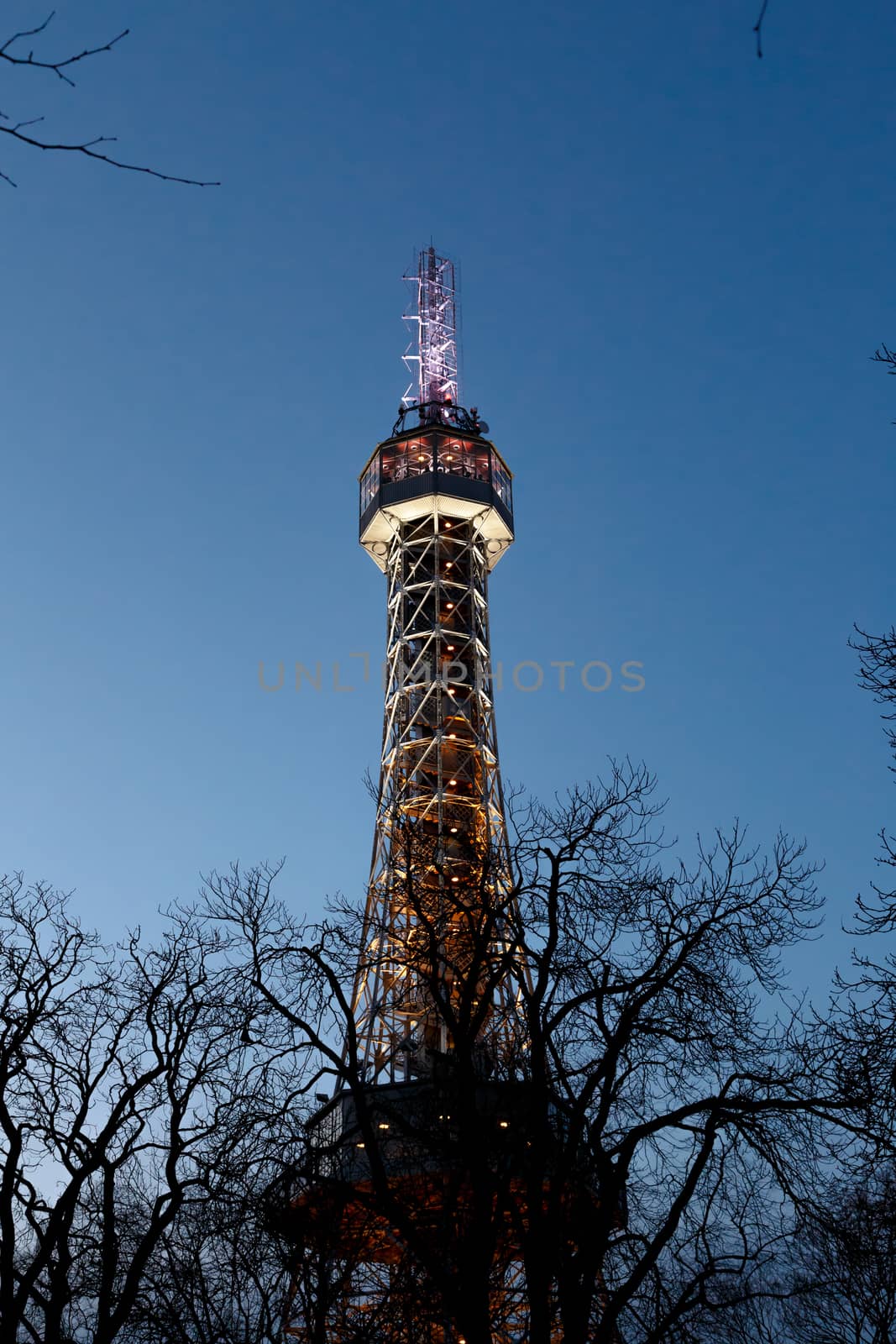 Bottom view of historical iron Petrin Tower, on bright blue sky background at sunset time.
