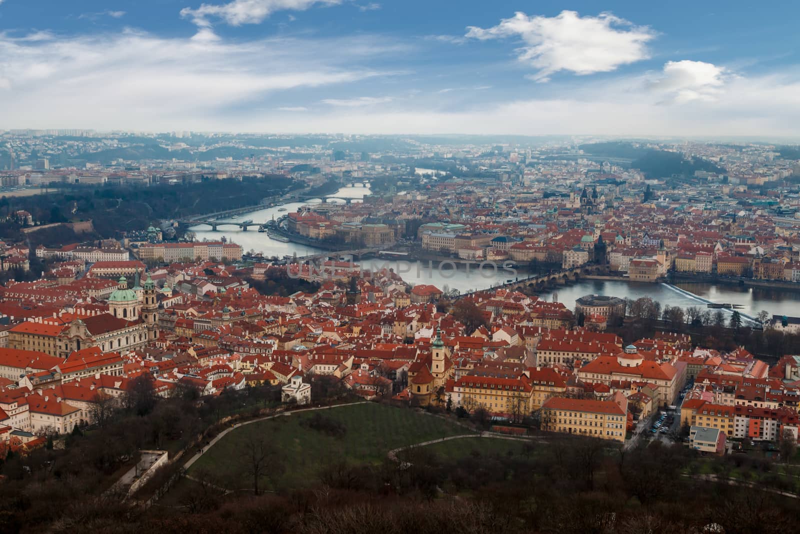 General top view of historical gothic Prague cityscape with old buildings and towers around, on cloudy sky background.