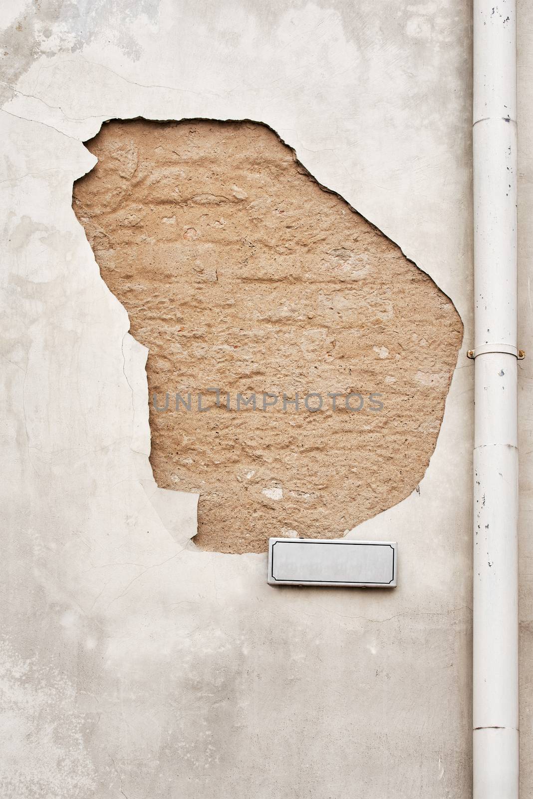 cracked  wall with street sign and rain water pipe