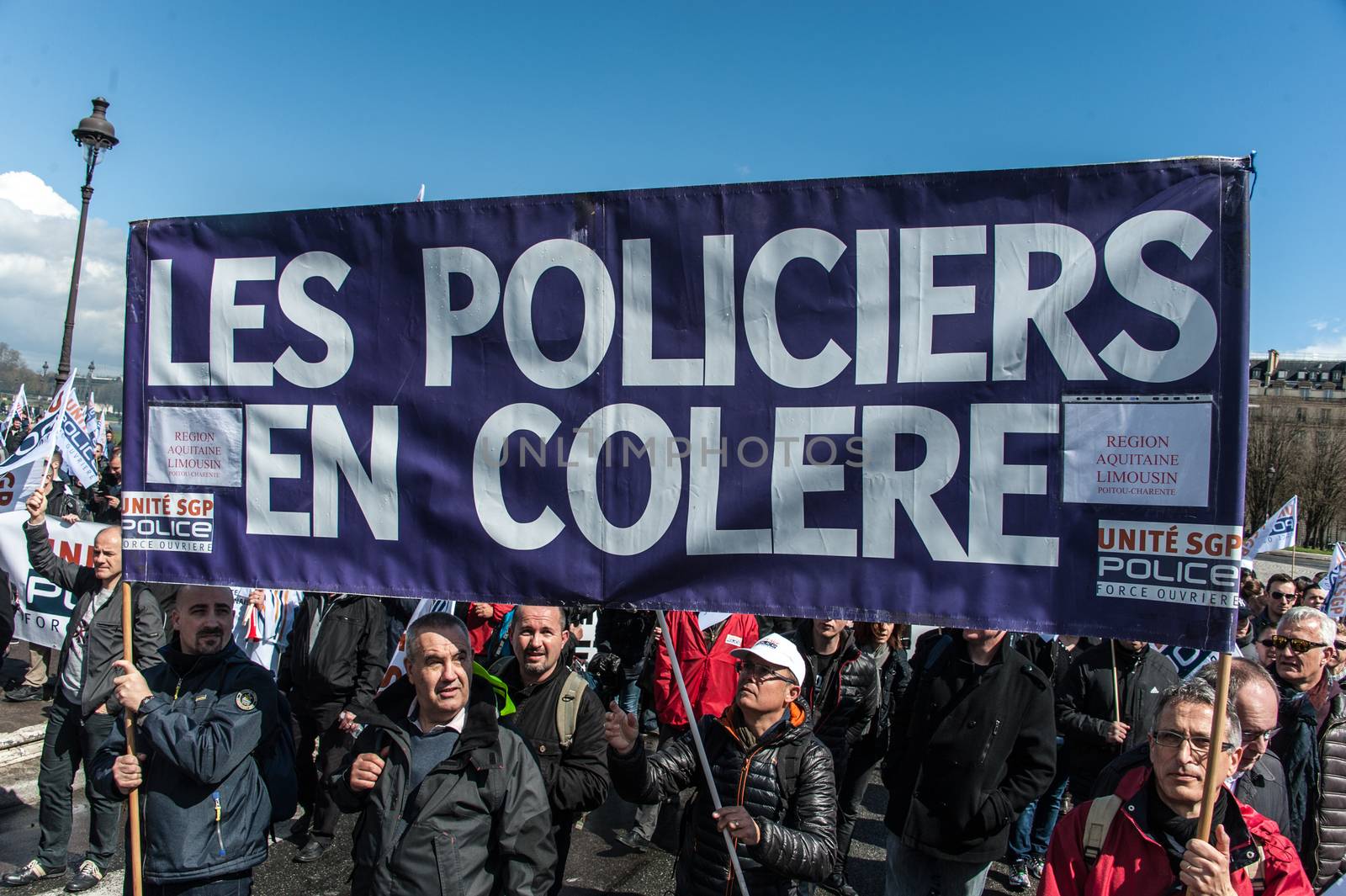 FRANCE, Paris : Police officers wave union flags as they take part in a protest called by the Unite-police SGP-FO police officers' union in Paris on April 7, 2016.A few thousand police officers, 8,000 according to organizers and 2,000 according to other police sources, demonstrated in Paris to demand the increase of a risk premium, in the wake of recent attacks and the state of emergency that is wearing out forces. 