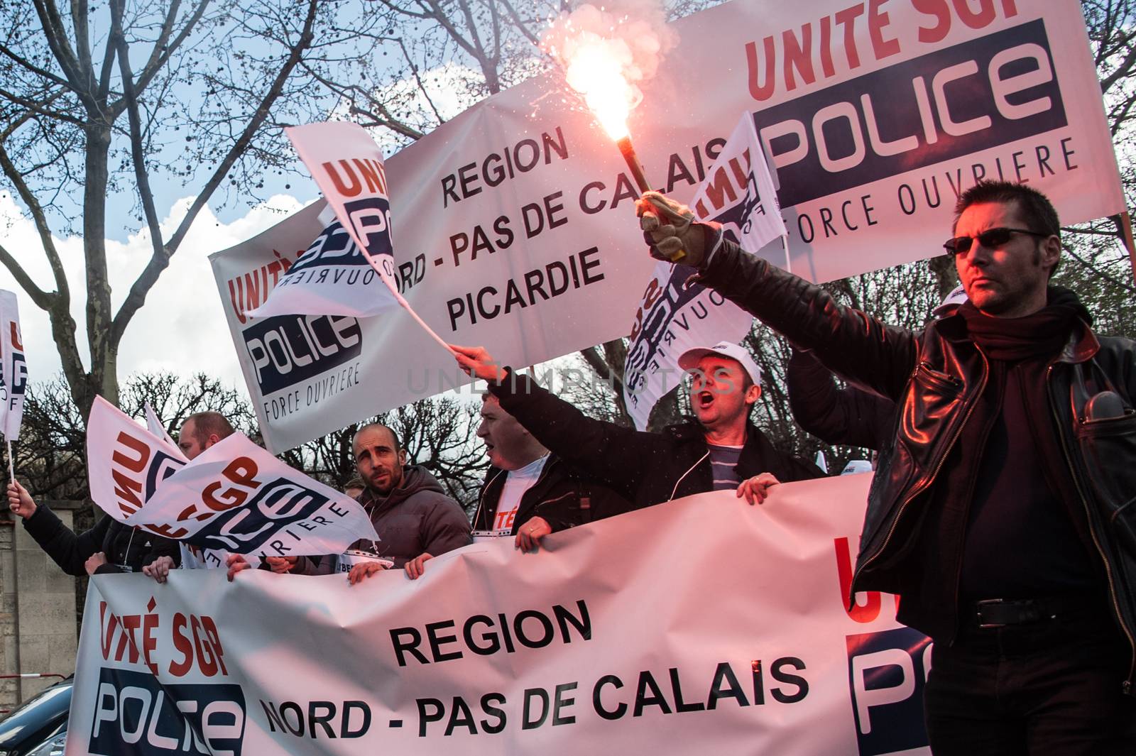 FRANCE, Paris : Police officers wave union flags as they take part in a protest called by the Unite-police SGP-FO police officers' union in Paris on April 7, 2016.A few thousand police officers, 8,000 according to organizers and 2,000 according to other police sources, demonstrated in Paris to demand the increase of a risk premium, in the wake of recent attacks and the state of emergency that is wearing out forces. 