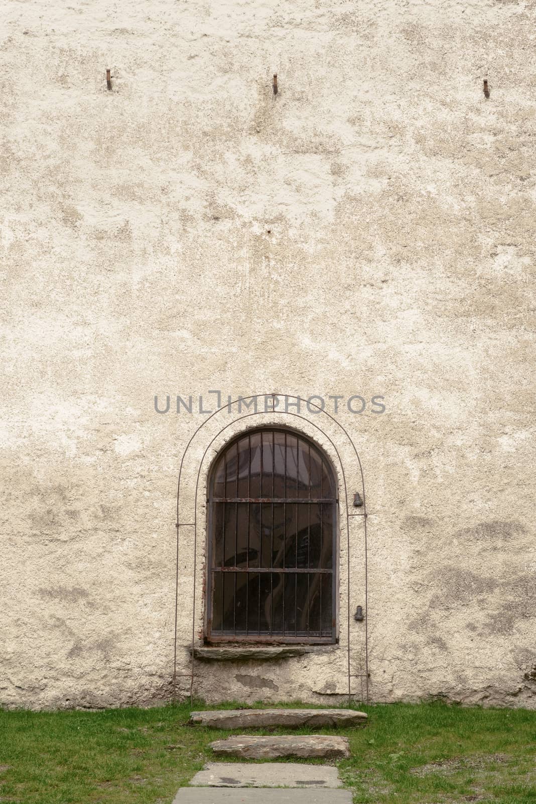 arch with window in stucco wall of old church