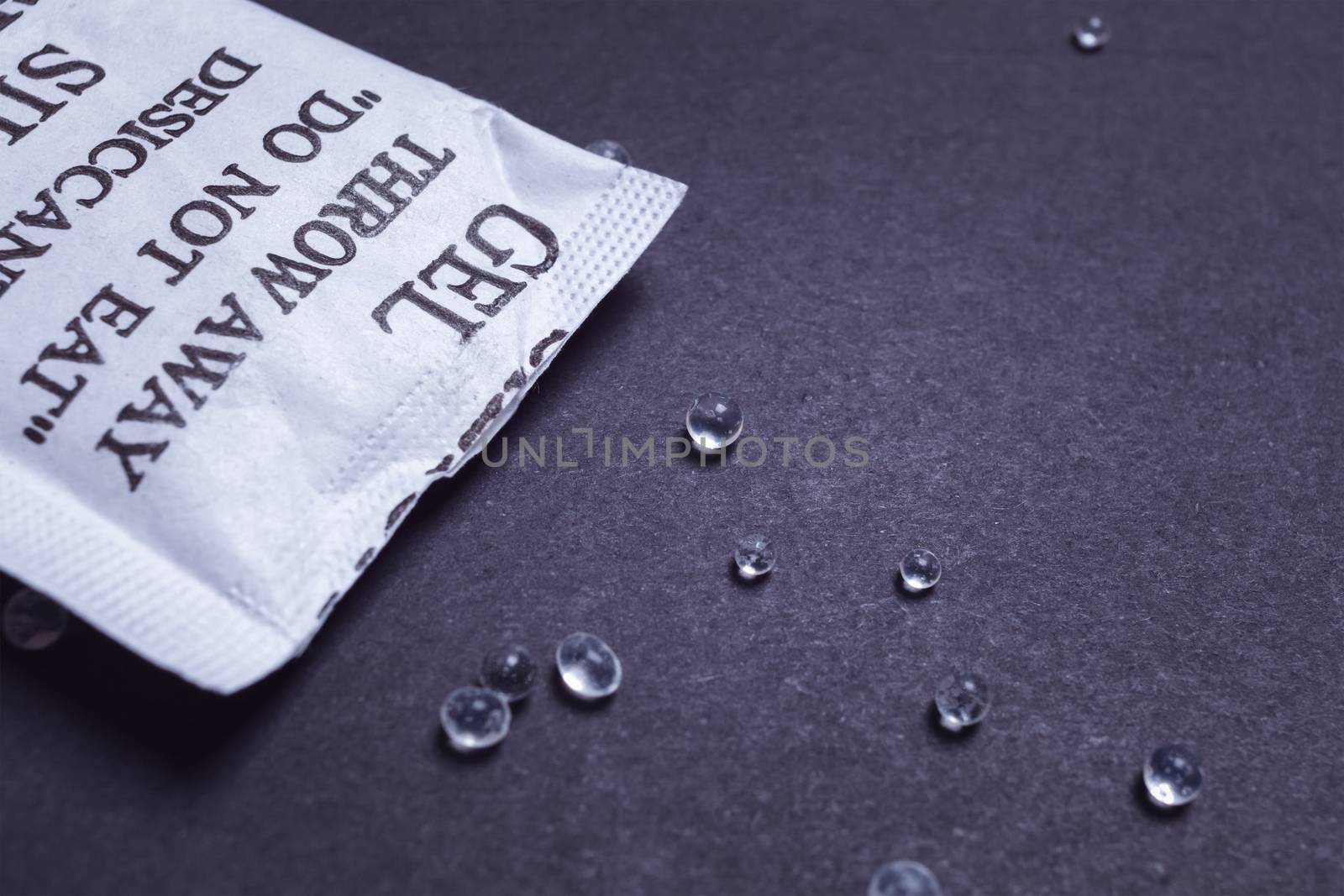 Close up silica gel or desiccant in paper bag on black backgroun by FrameAngel