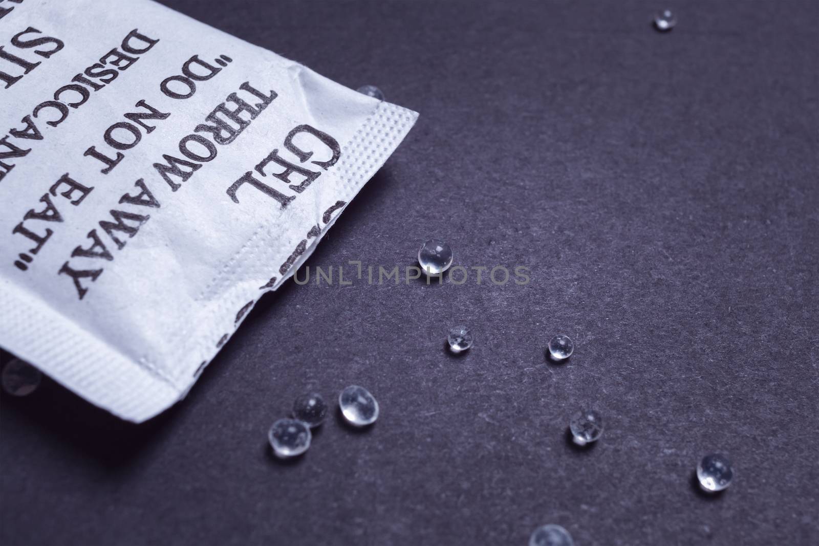 Close up silica gel or desiccant in paper bag on black background