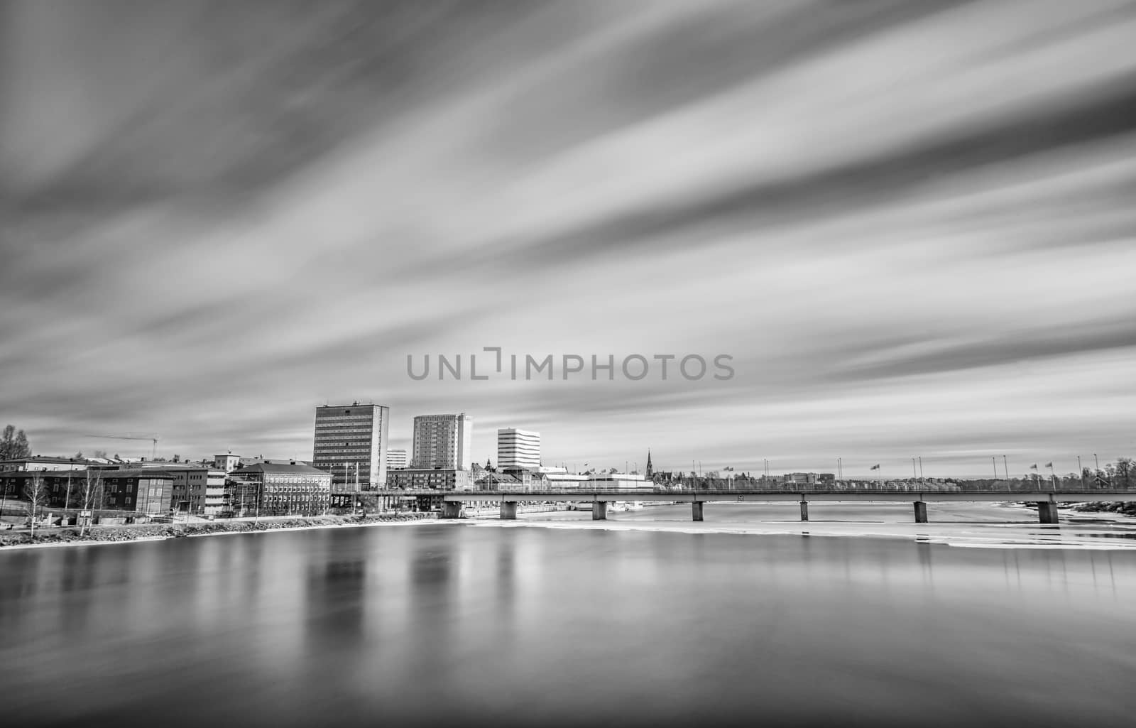 Downtown Umeå, Sweden with some ice in the river and clouds.