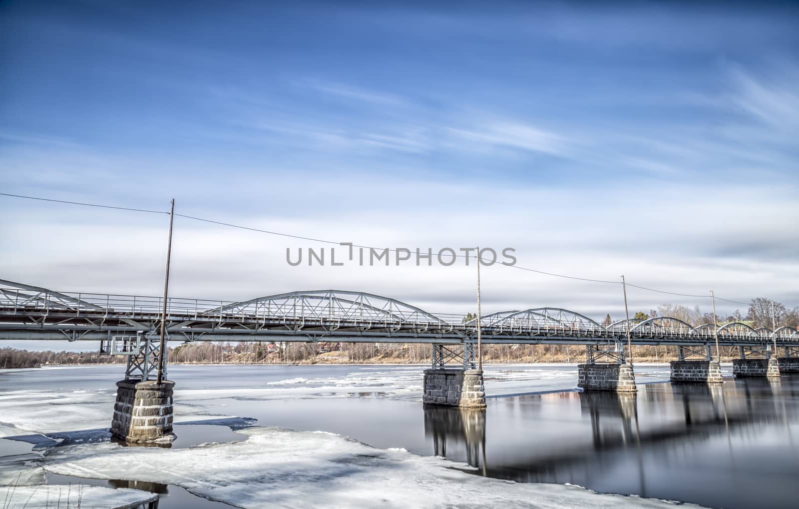 Old Bridge in Umeå, Sweden with ice in the river and clouds in the sky.
