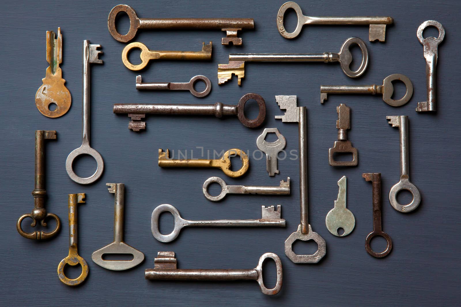 Set of old keys on a gray wooden board