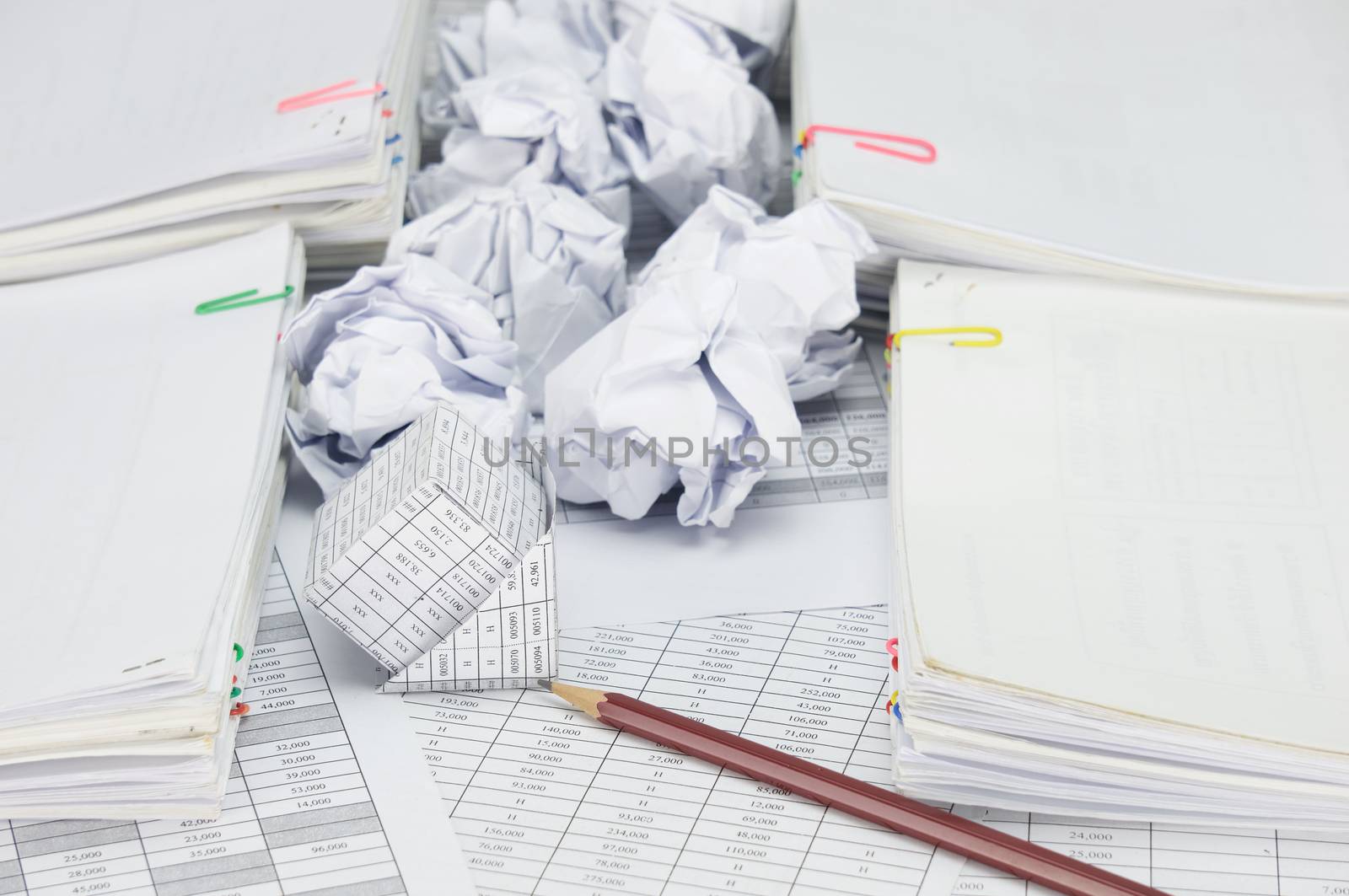 Bankruptcy of house with pencil on finance account have blur paper ball between pile of paperwork as background.