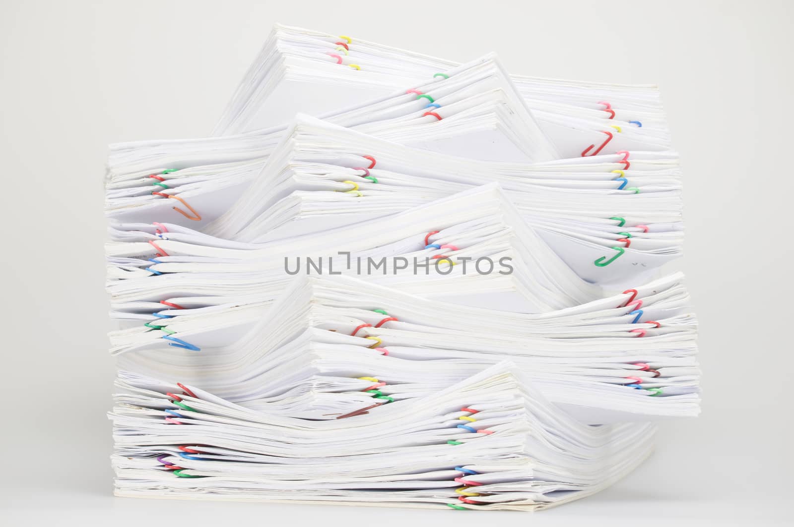 Overload document of receipt and report with colorful paperclip on white table.