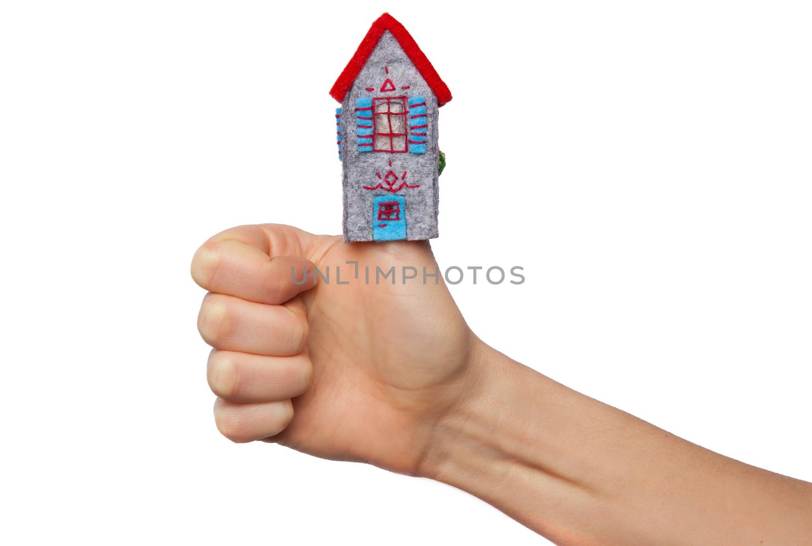 Toy house put on the thumb isolated on white background
