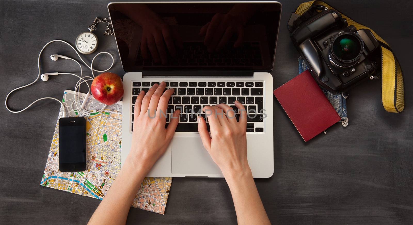 Outfit of the traveler. The view from the top. young woman sitting at the vintage brown wooden table for computer