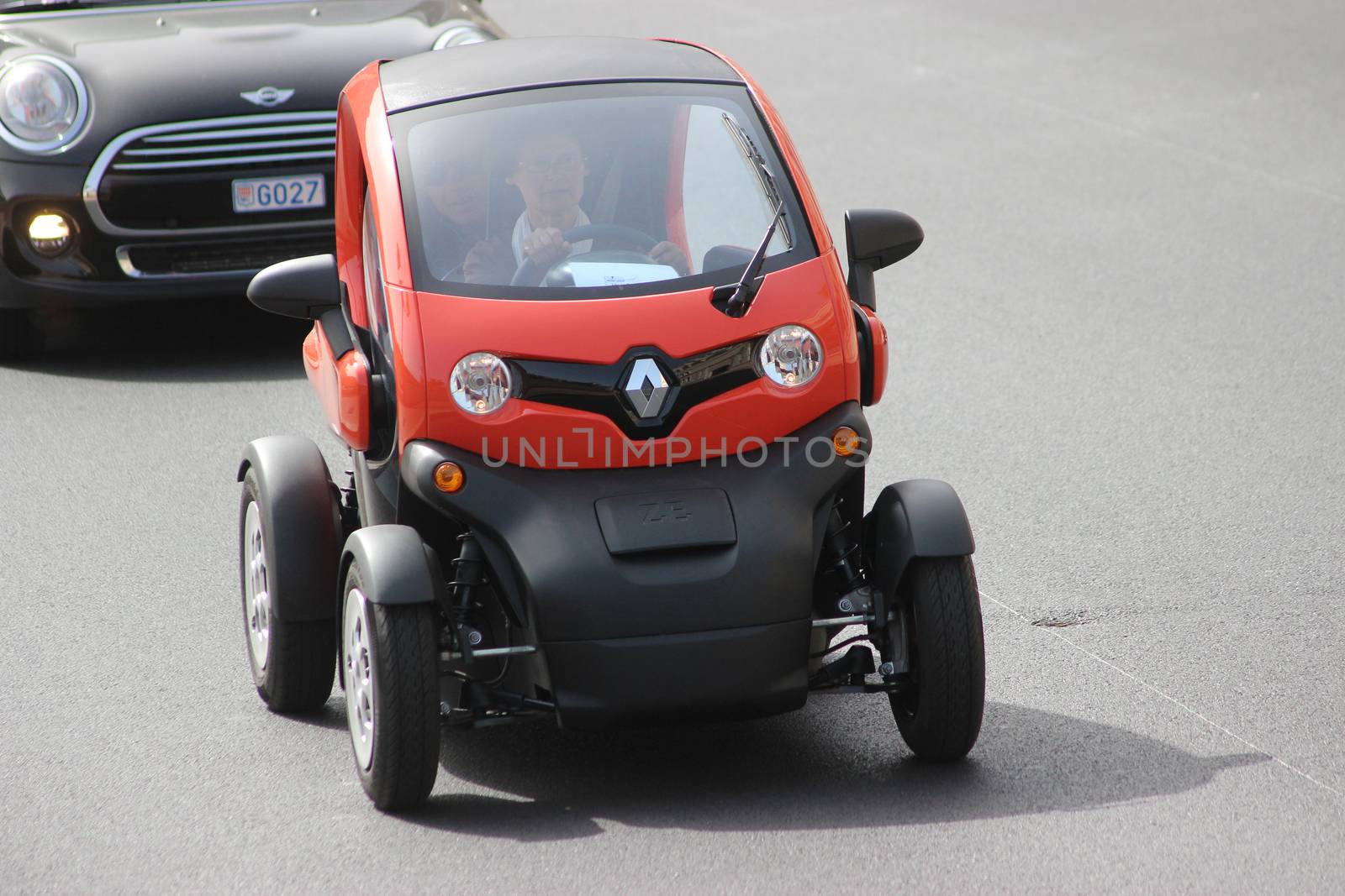 Monte-Carlo, Monaco - April 6, 2016: Red Electric Car Renault Twizy on Avenue d'Ostende in Monaco. Old Woman Driving an Electric Car Renault Twizy in the south of France