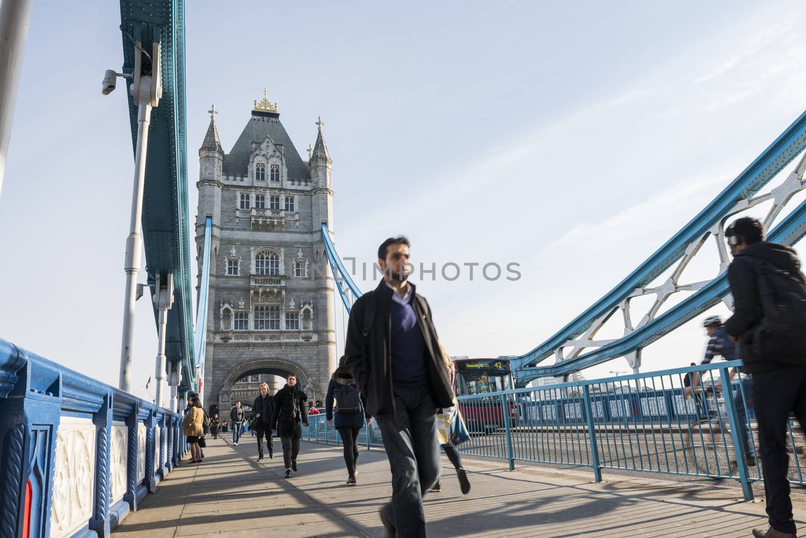 LONDON, UK – APRIL 01 2016: Commuters crossing Tower Bridge during rush hour. Tower Bridge links the South of River Thames to the City area.