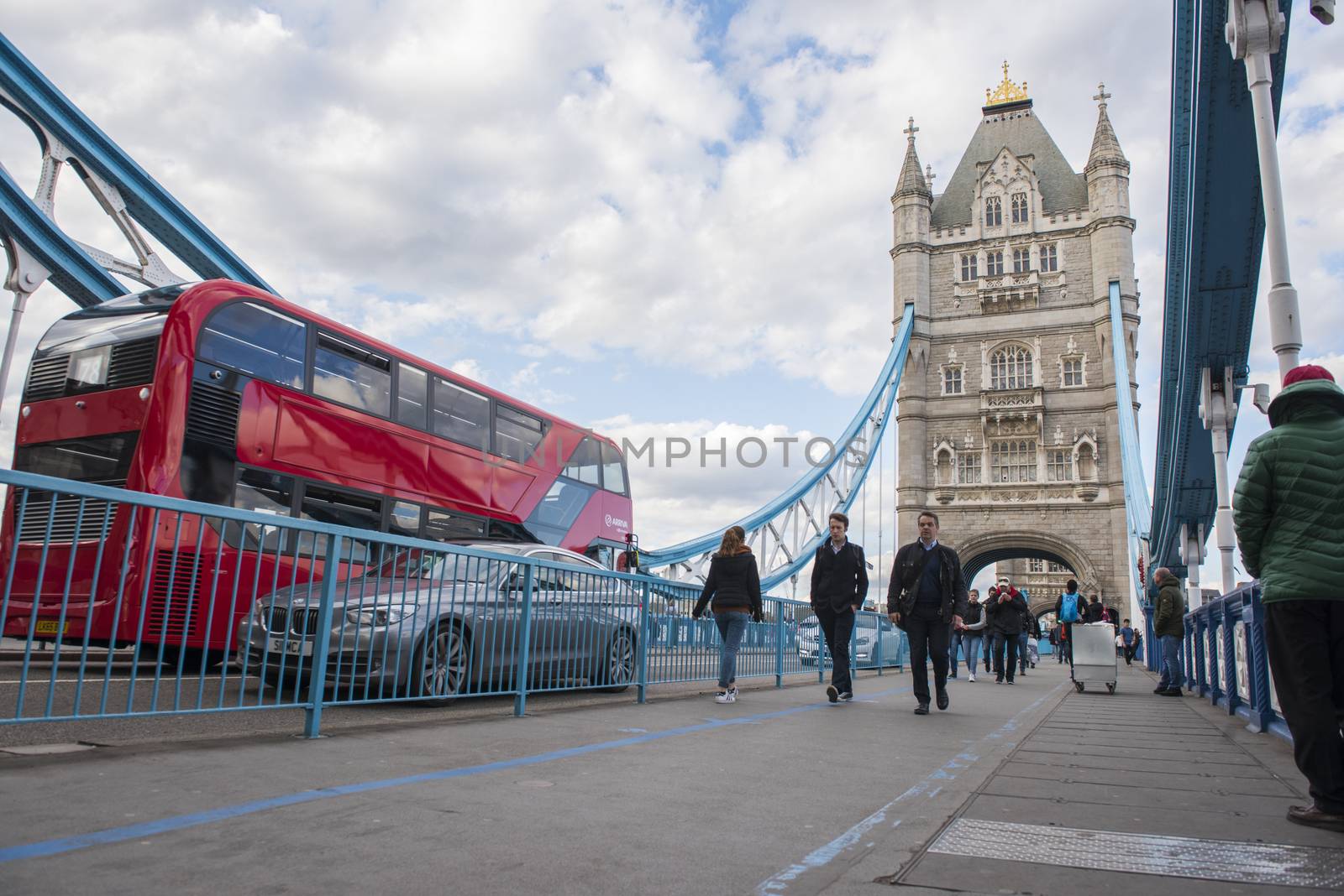 LONDON, UK – APRIL 05 2016: Commuters crossing Tower Bridge during rush hour. Tower Bridge links the South of River Thames to the City area.