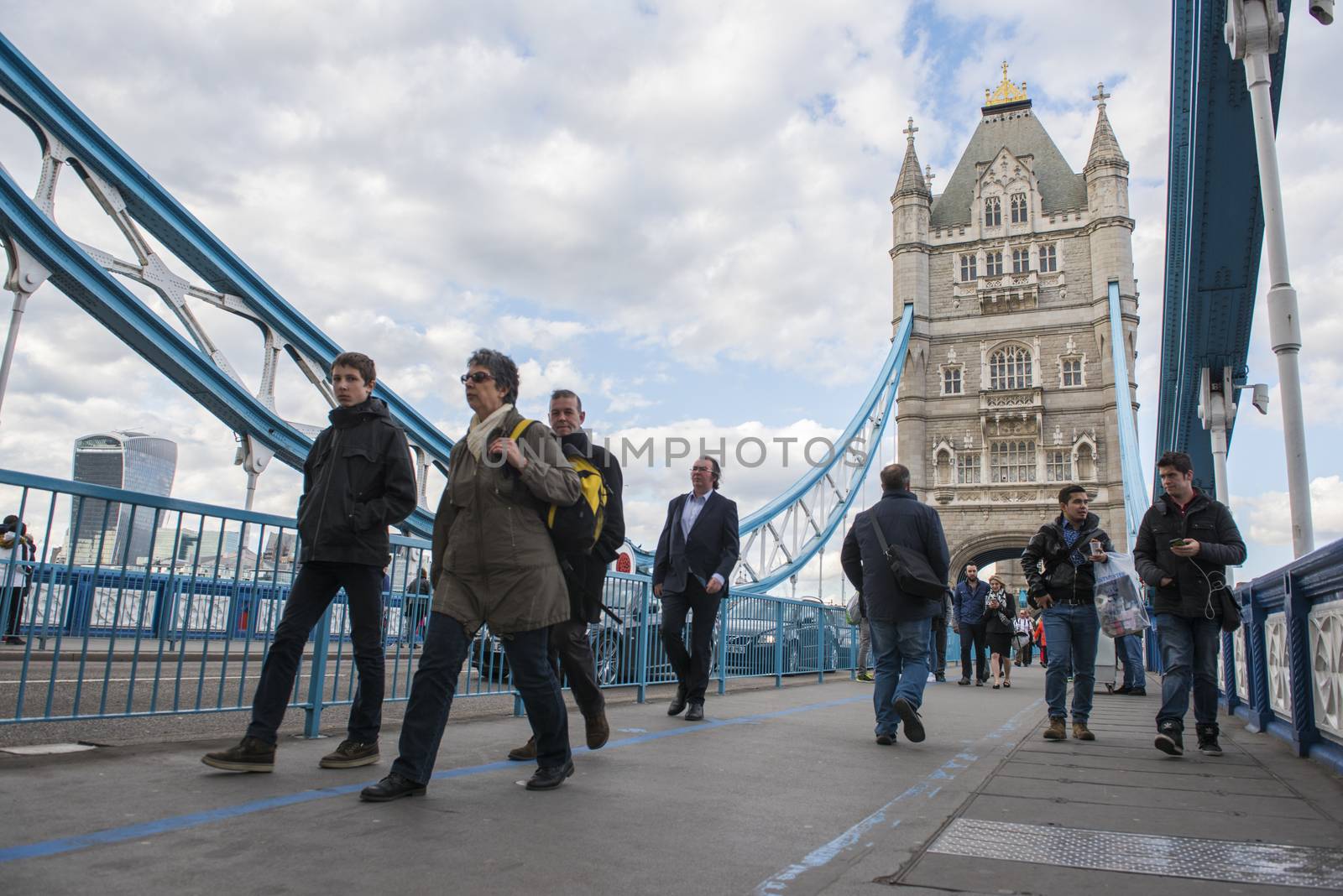 LONDON, UK – APRIL 05 2016: Commuters crossing Tower Bridge during rush hour. Tower Bridge links the South of River Thames to the City area.