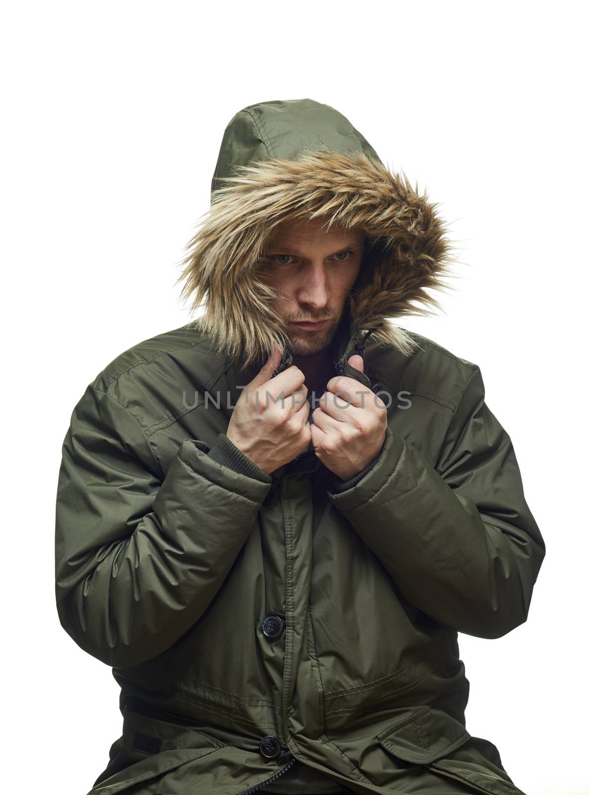 High key studio portrait of young adult caucasian model wearing winter coat with hood on looking sideways. Isolated on white.