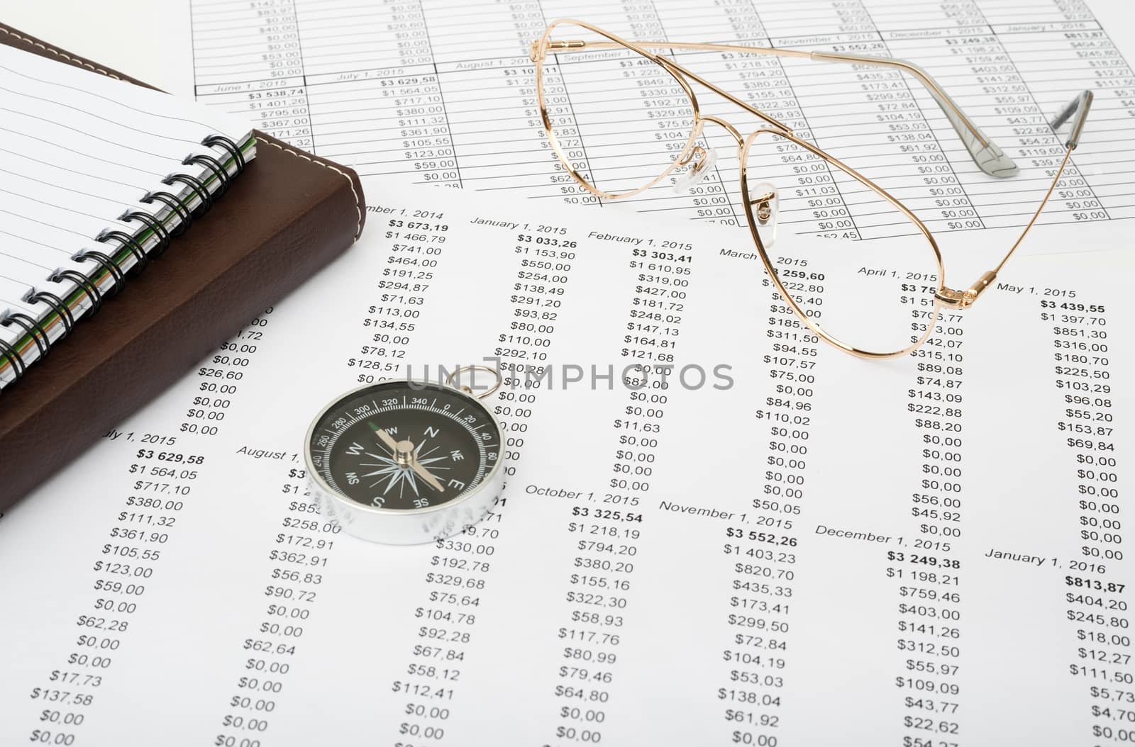 Notebook with glasses and compass on paper bill background, business concept