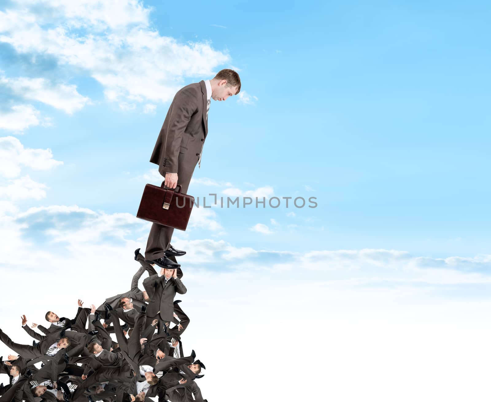 Businessman looking down from pile of people by cherezoff