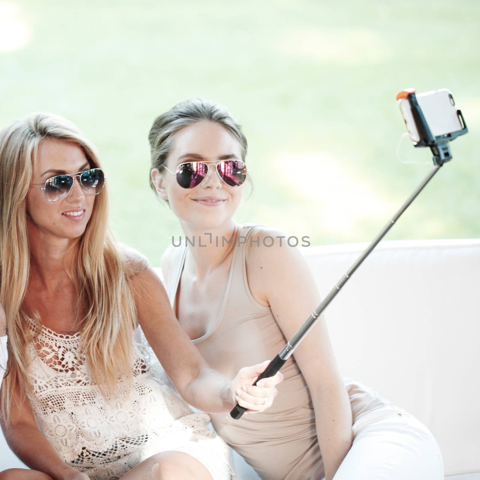 Young beautiful female friends taking selfie outdoors
