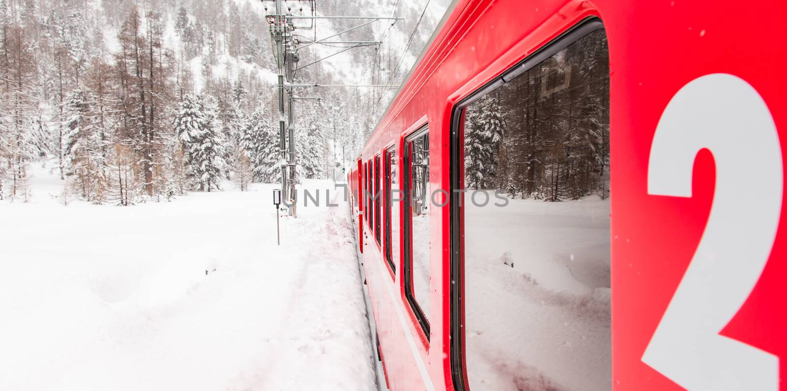 A red train in the middle of a desert of snow