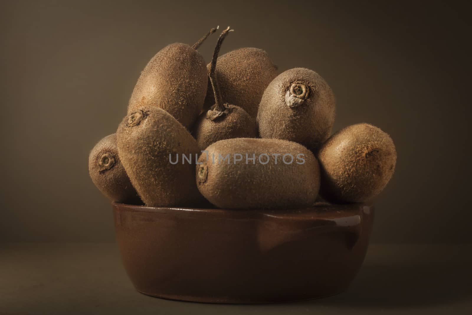 Kiwi in a bowl of brown on brown background to understand a principle of healthy eating