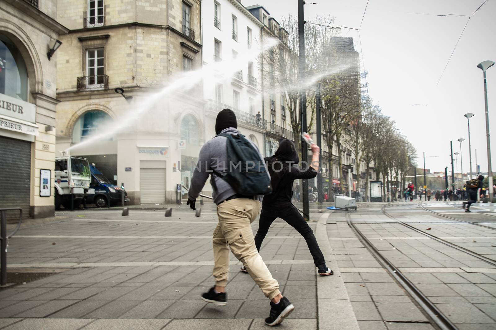 FRANCE, Nantes: Protesters are about to throw something to police forces during a demonstration on April 9, 2016 in Nantes, western France, against the French government's proposed labour law reforms. Fresh strikes by unions and students are being held across France against proposed reforms to France's labour laws, heaping pressure on President Francois Hollande who suffered a major defeat over constitutional reforms on March 30. 