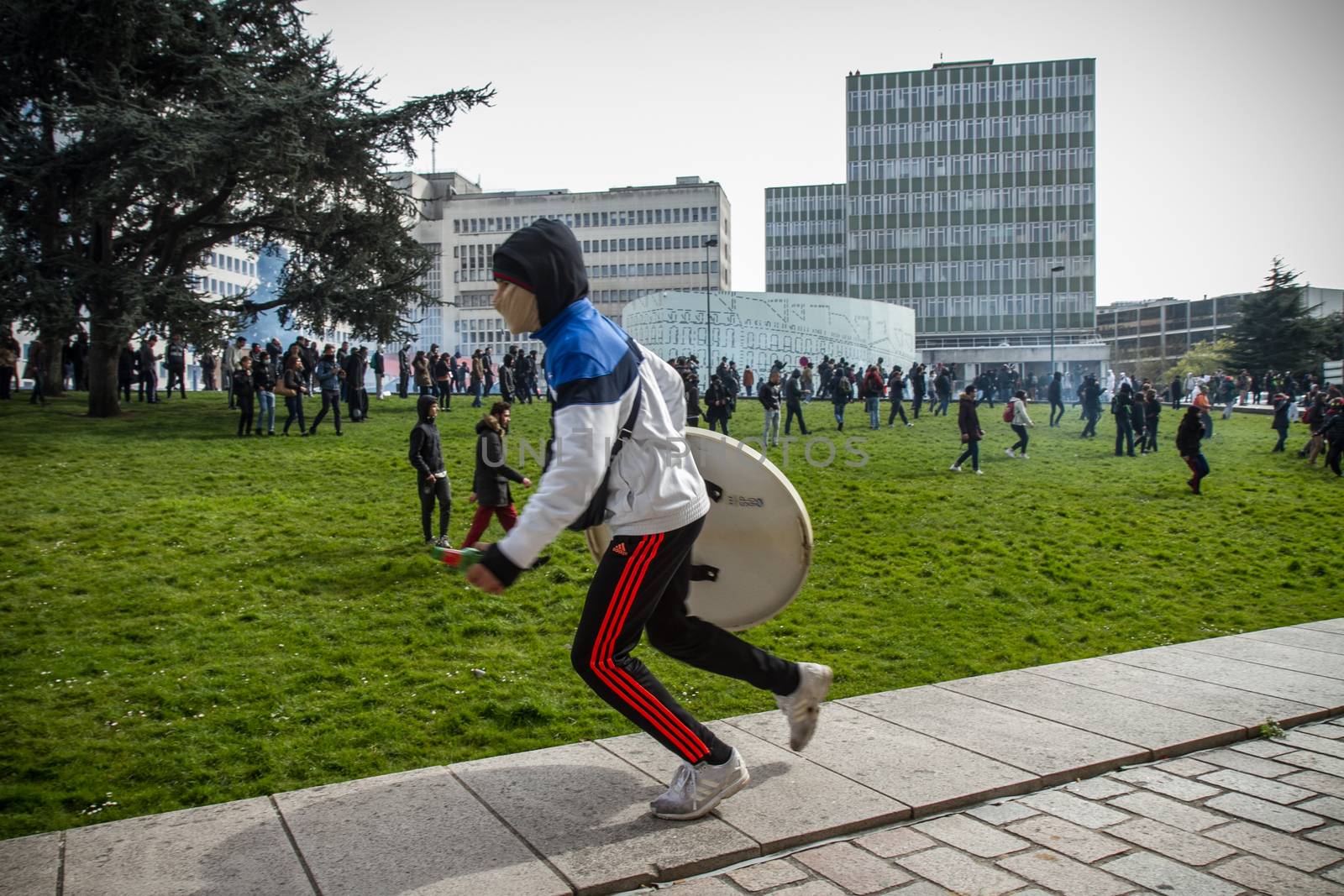 FRANCE, Nantes: A masked protester runs with a shield during a demonstration on April 9, 2016 in Nantes, western France, against the French government's proposed labour law reforms. Fresh strikes by unions and students are being held across France against proposed reforms to France's labour laws, heaping pressure on President Francois Hollande who suffered a major defeat over constitutional reforms on March 30. 