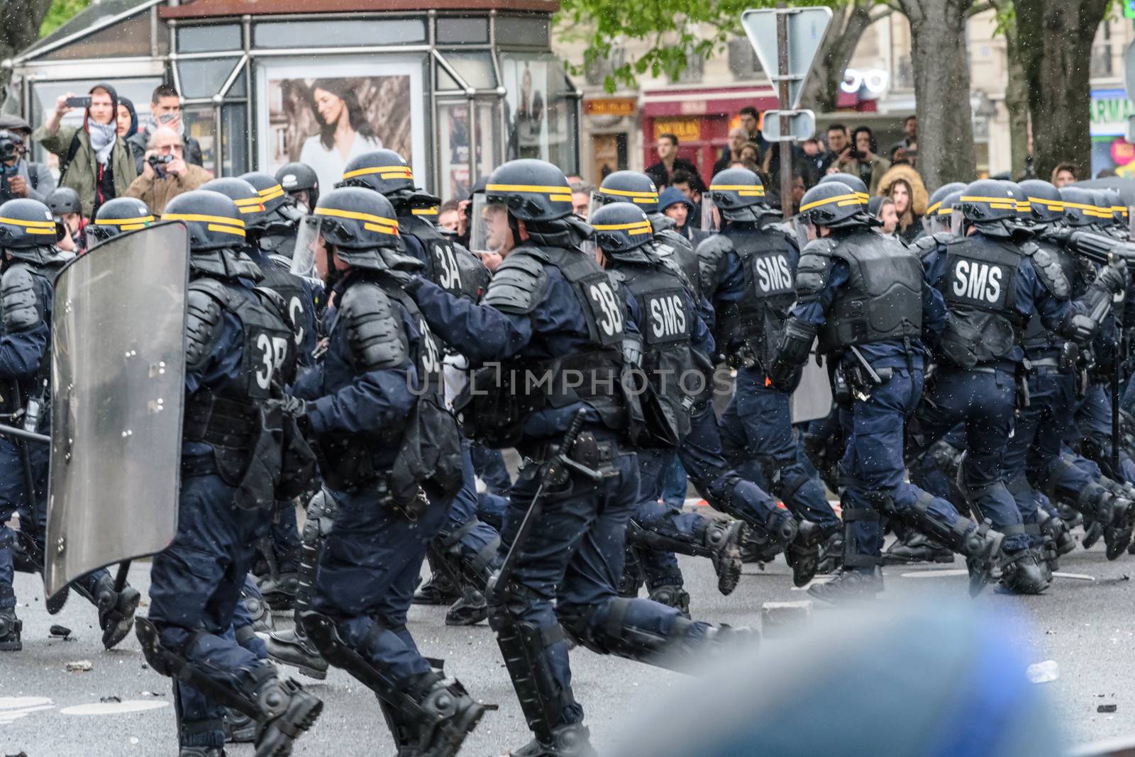 FRANCE, Paris: Riot policemen rush toward the crowd during a protest on April 9, 2016 in Paris, against the French government's proposed labour law reforms.