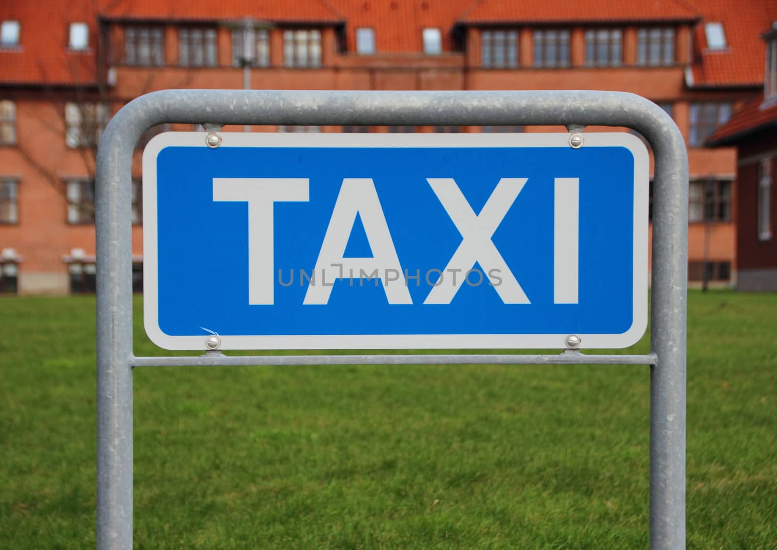 Taxi Sign Closeup with Building and Grass Background by HoleInTheBox