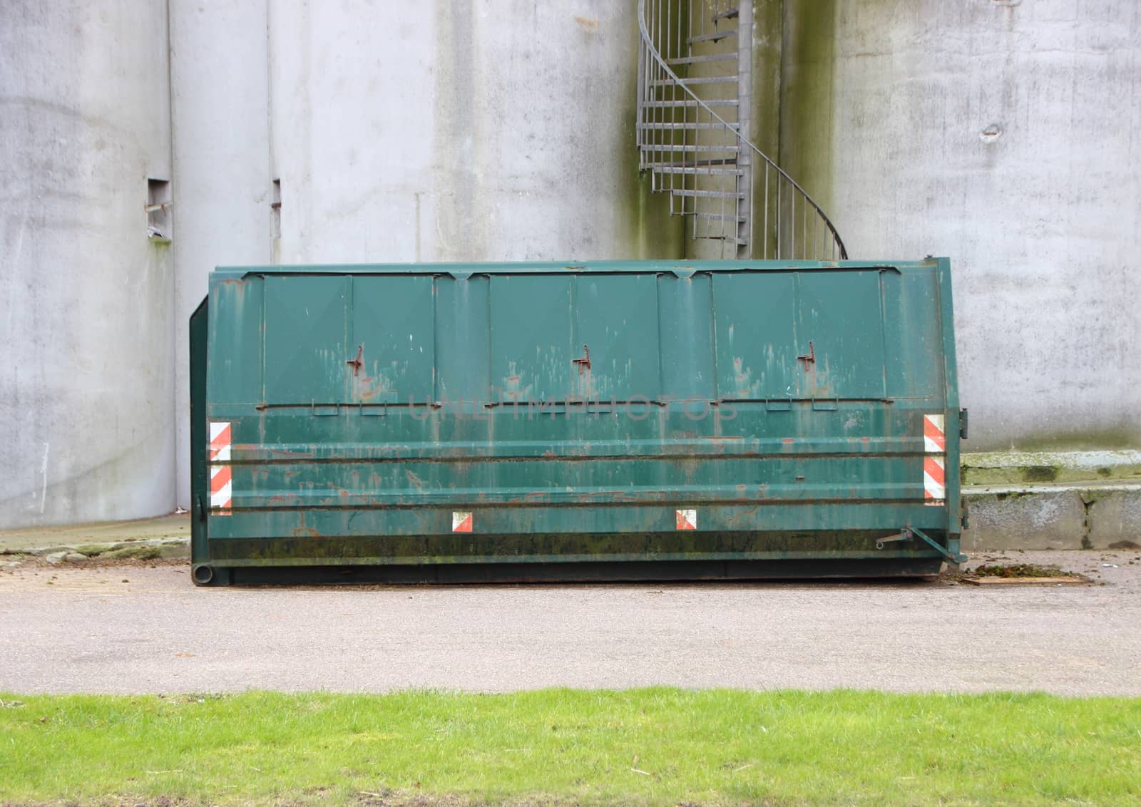 Green Worn Industrial Container with Concrete Wall Background and Staircase