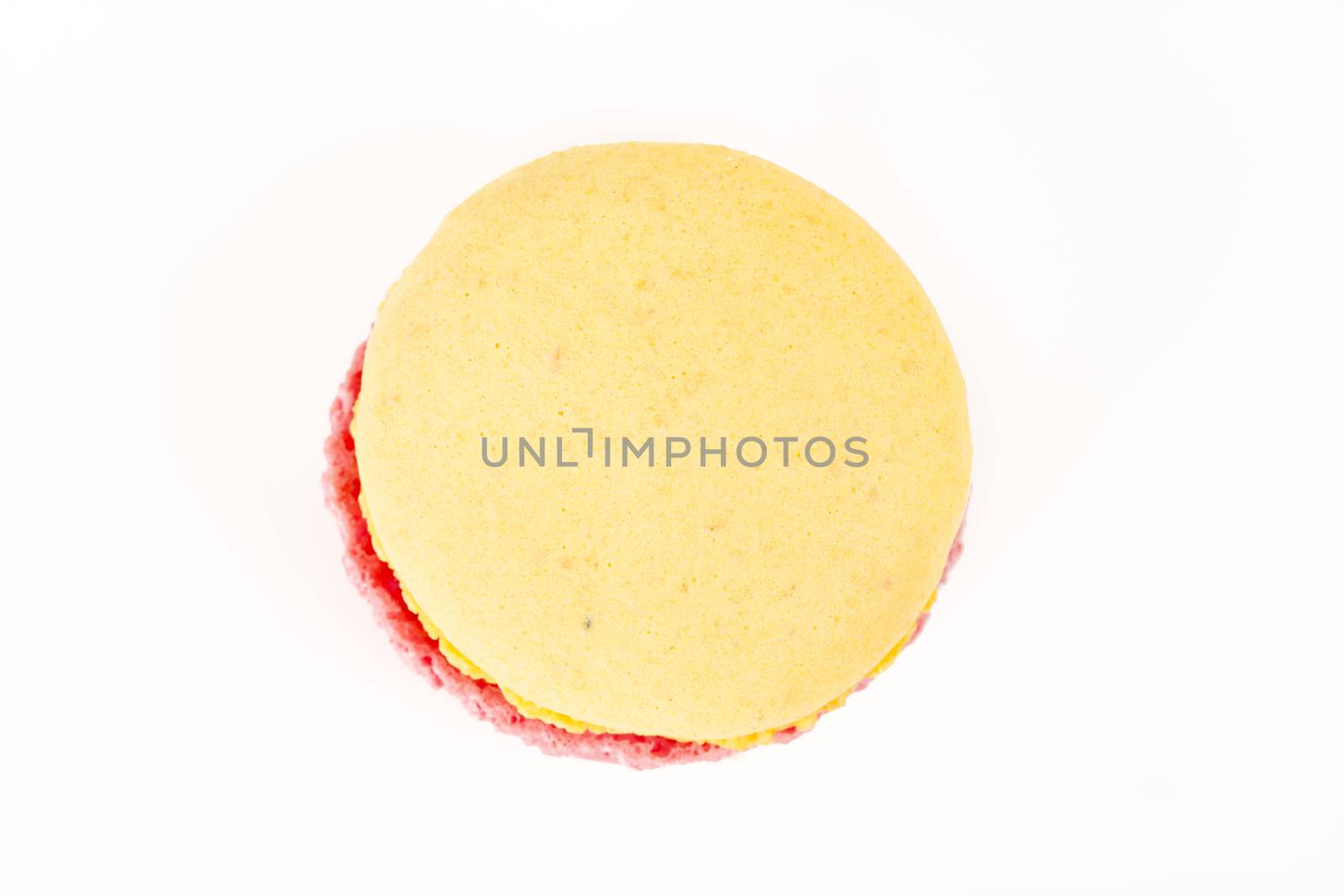 French colorful home made pink yellow macarons on white bakground