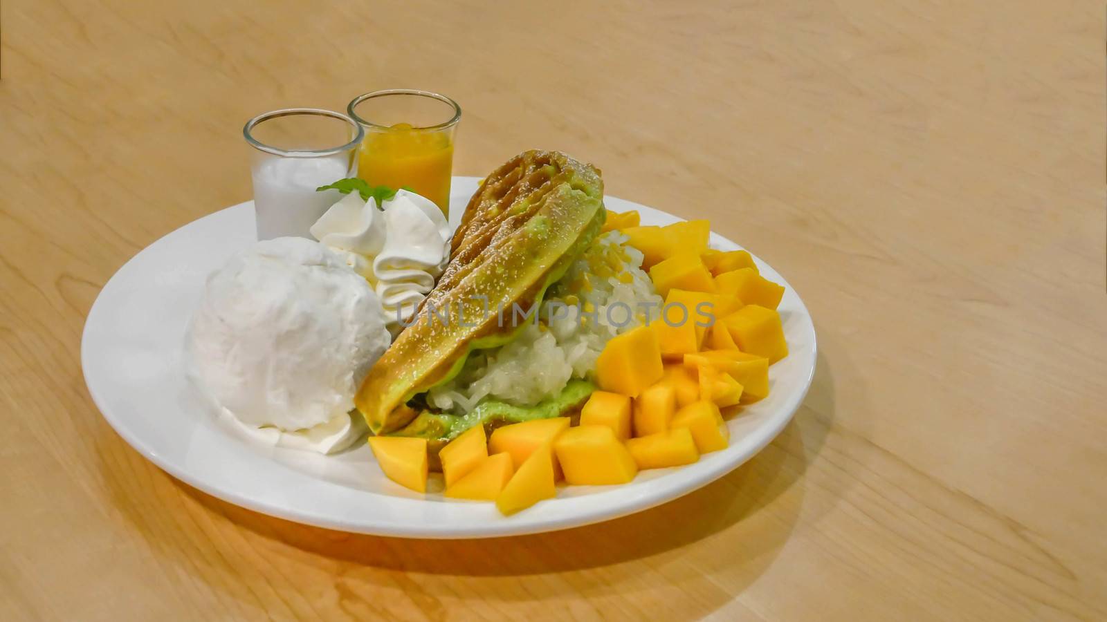 waffles served with ice cream , ripe mango and sweet sticky rice on plate