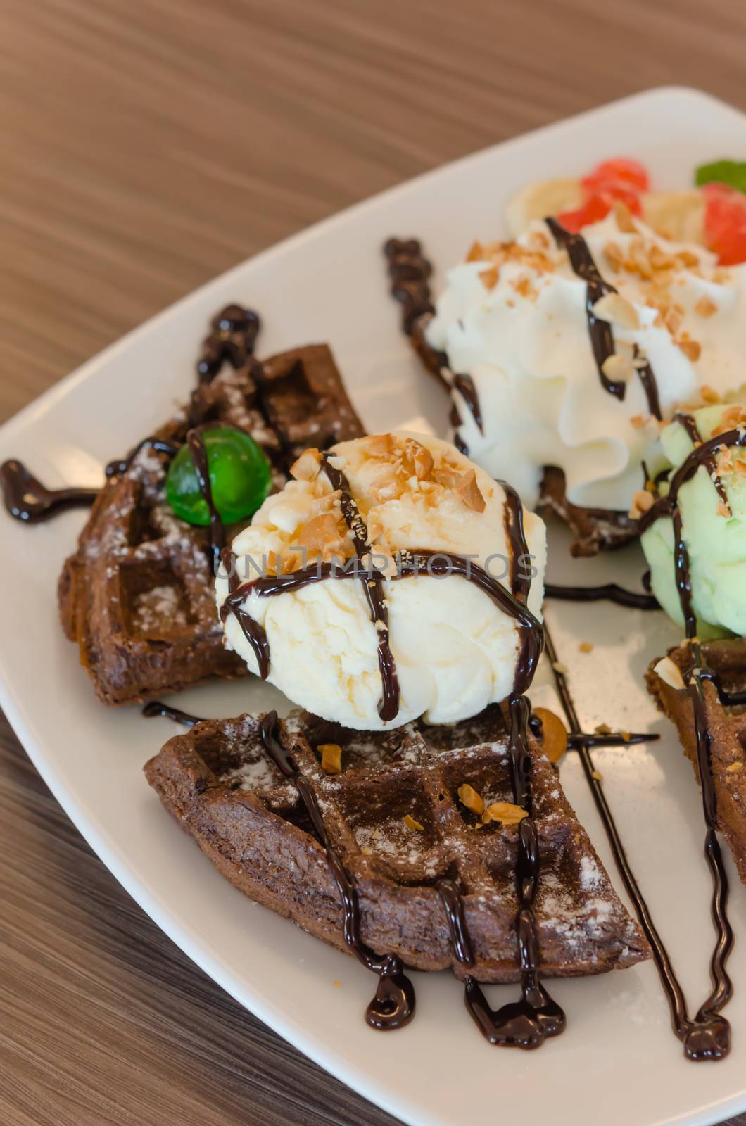 ice cream , chocolate waffles with chocolate sauce and whipping cream