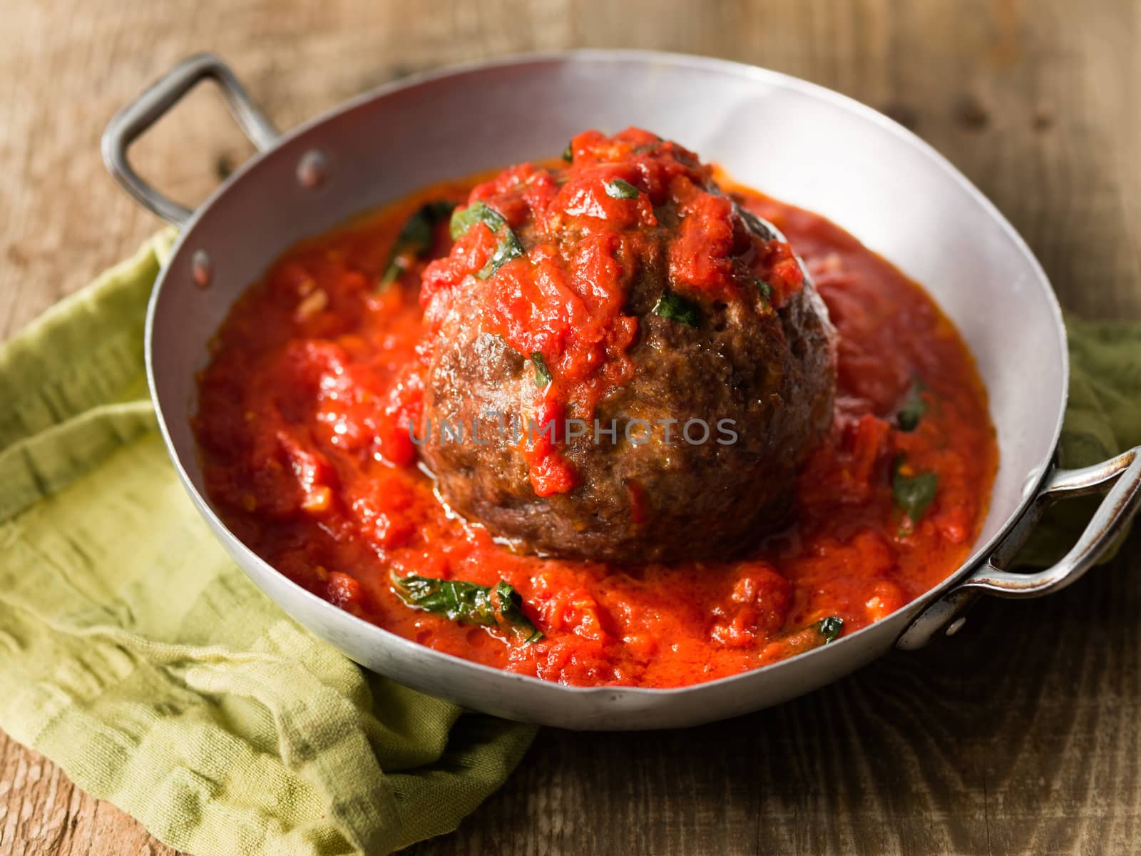 close up of rustic italian meatball in tomato sauce