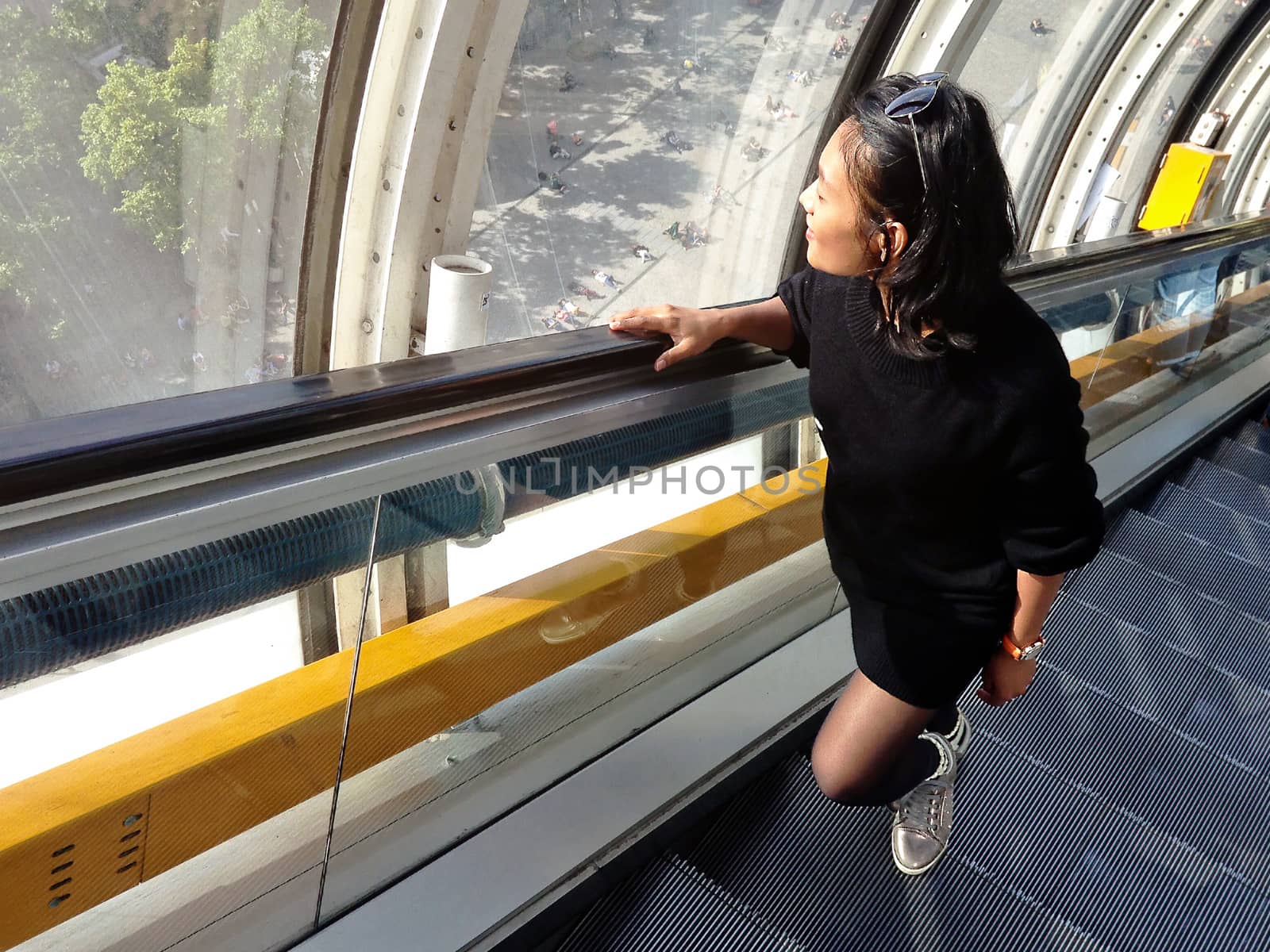 Young asian woman on elevator looking out