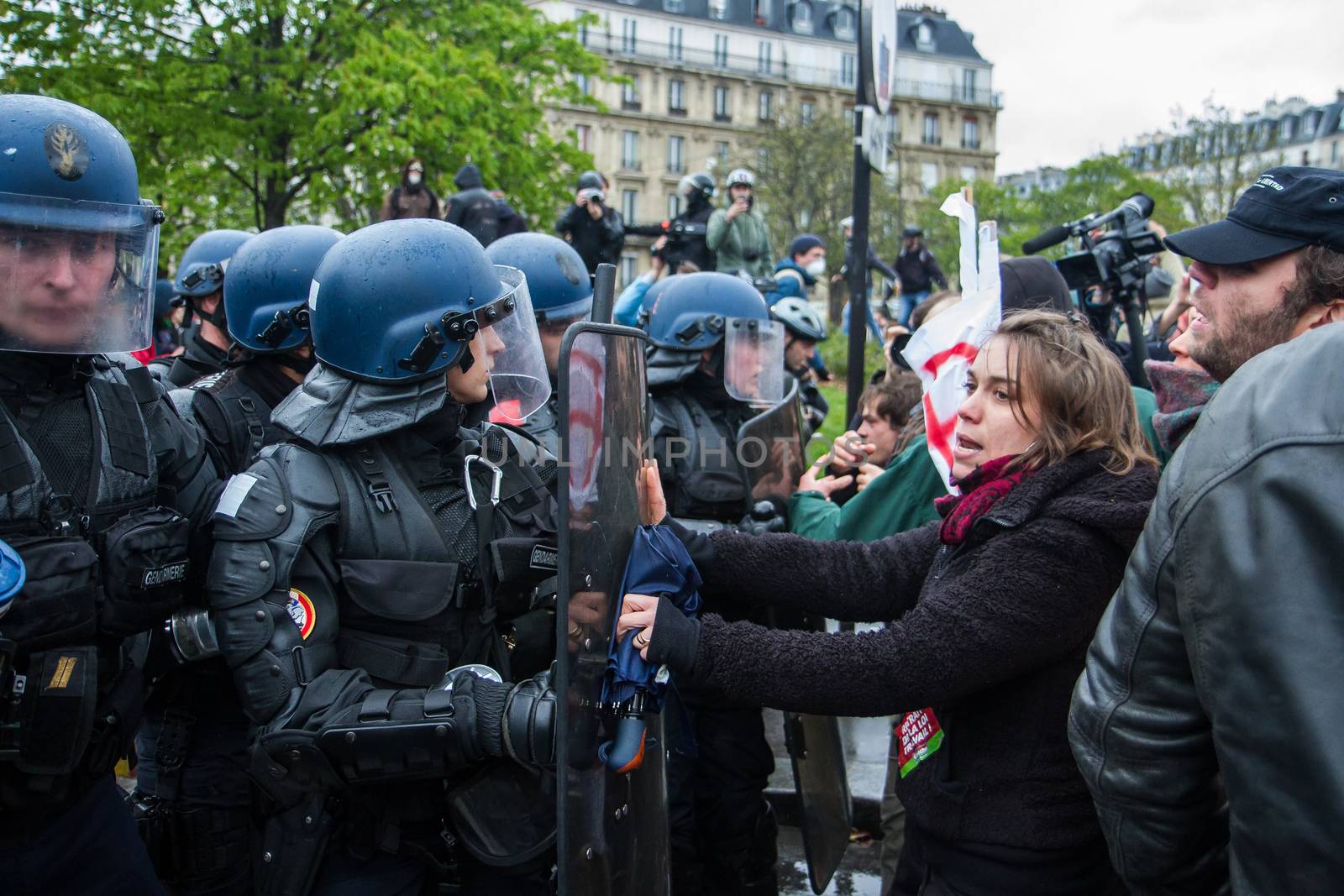 FRANCE, Paris: A protester holds the shield of a riot policeman during a demo on April 9, 2016 in Paris, against the French government's proposed labour law reforms.