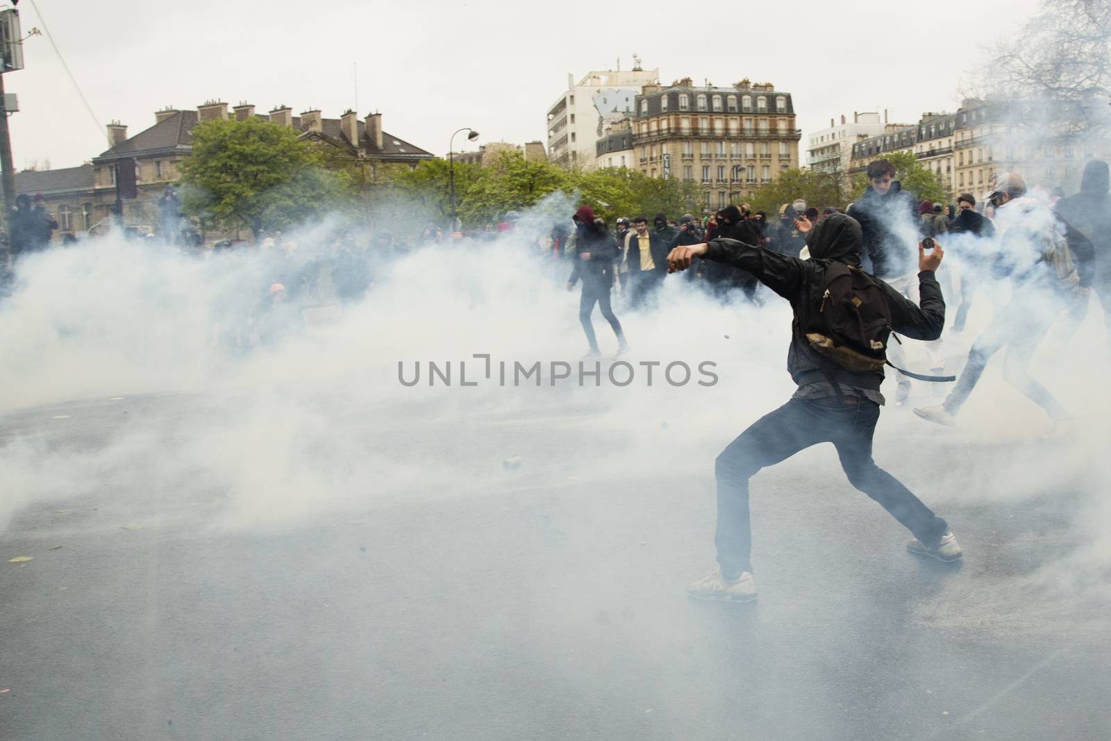 FRANCE, Paris: A protester throws an unidentifiable item to riot police at the end of a demonstration against planned labour reforms, in Paris, France, on April 9, 2016.